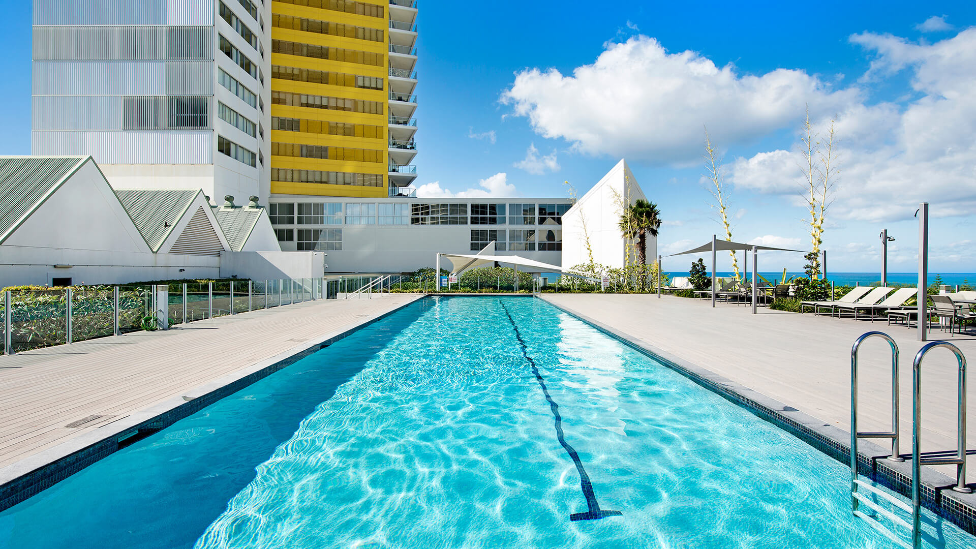 Resort-style outdoor swimming pool with sun loungers and ocean views at ULTIQA Air on Broadbeach.