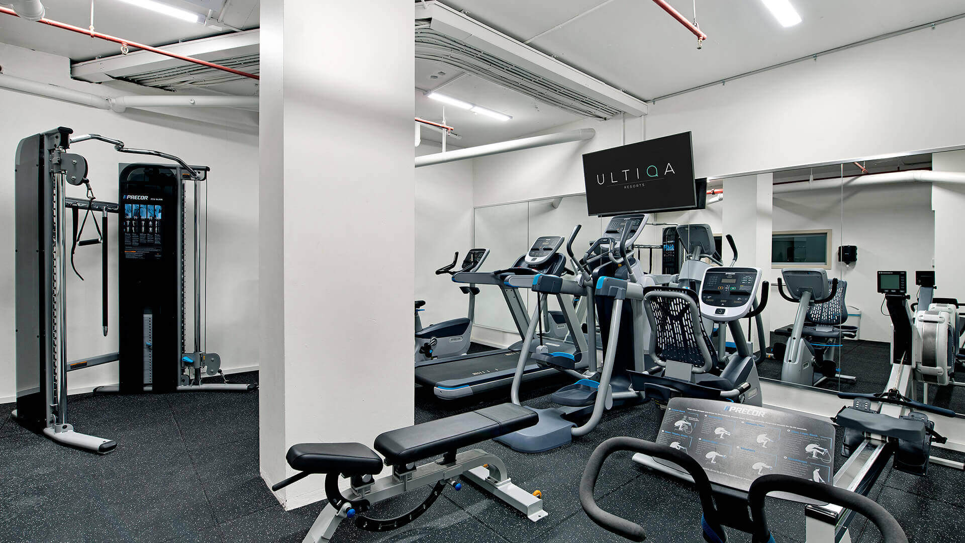 Fully equipped fitness centre at ULTIQA Beach Haven featuring treadmills, cross trainers, weights and cardio machines for guest use.