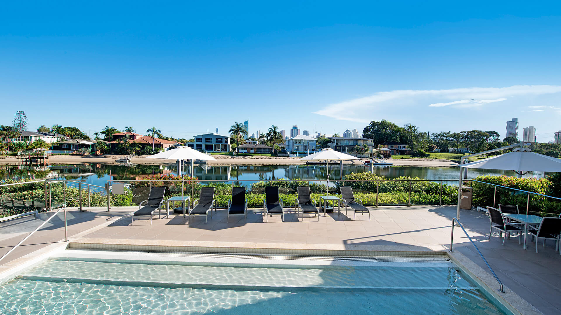 Resort pool with sun loungers and waterfront views at ULTIQA Freshwater Point Resort, Broadbeach.