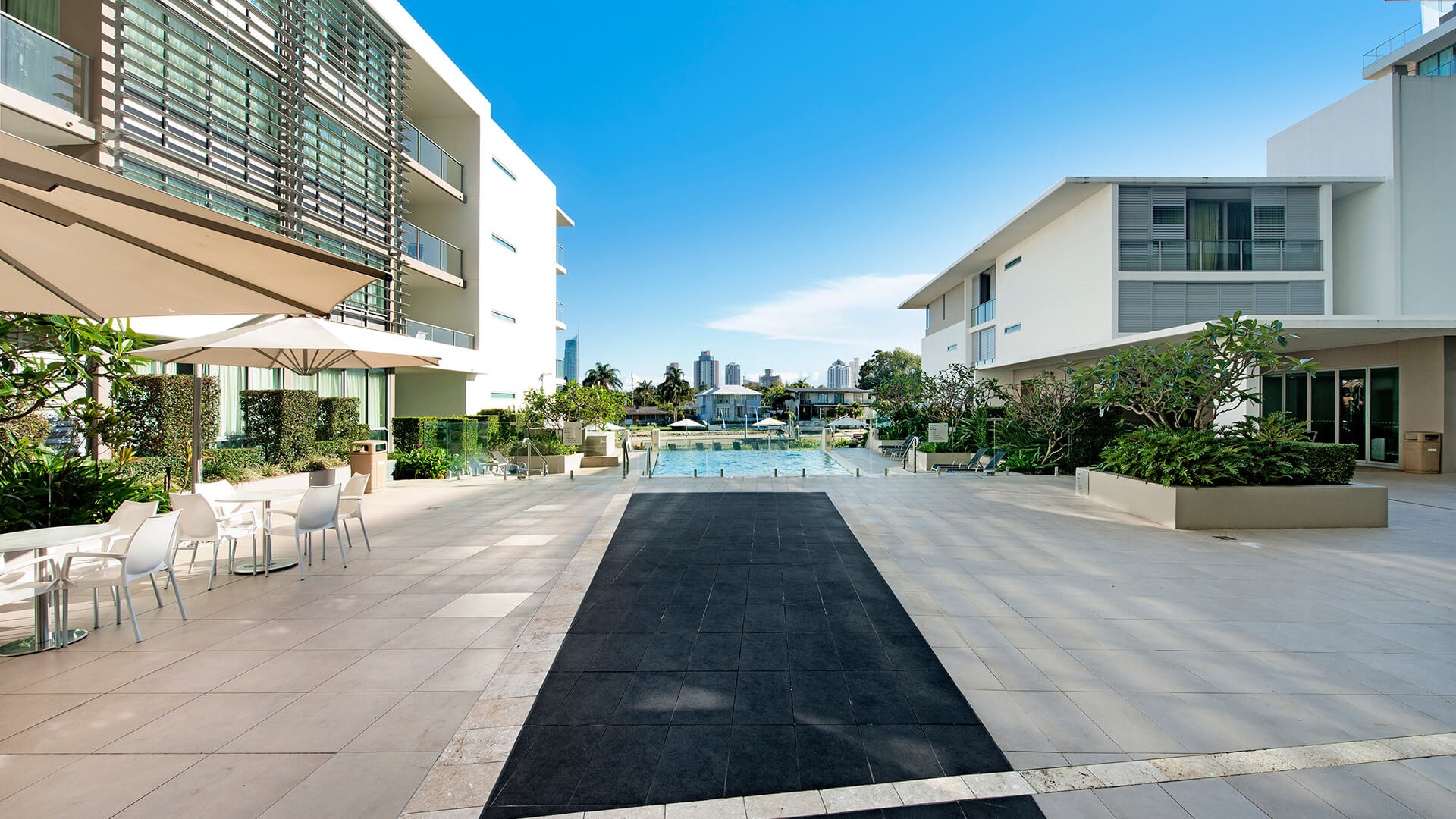 Outdoor dining and pool area at ULTIQA Freshwater Point Resort, Broadbeach.