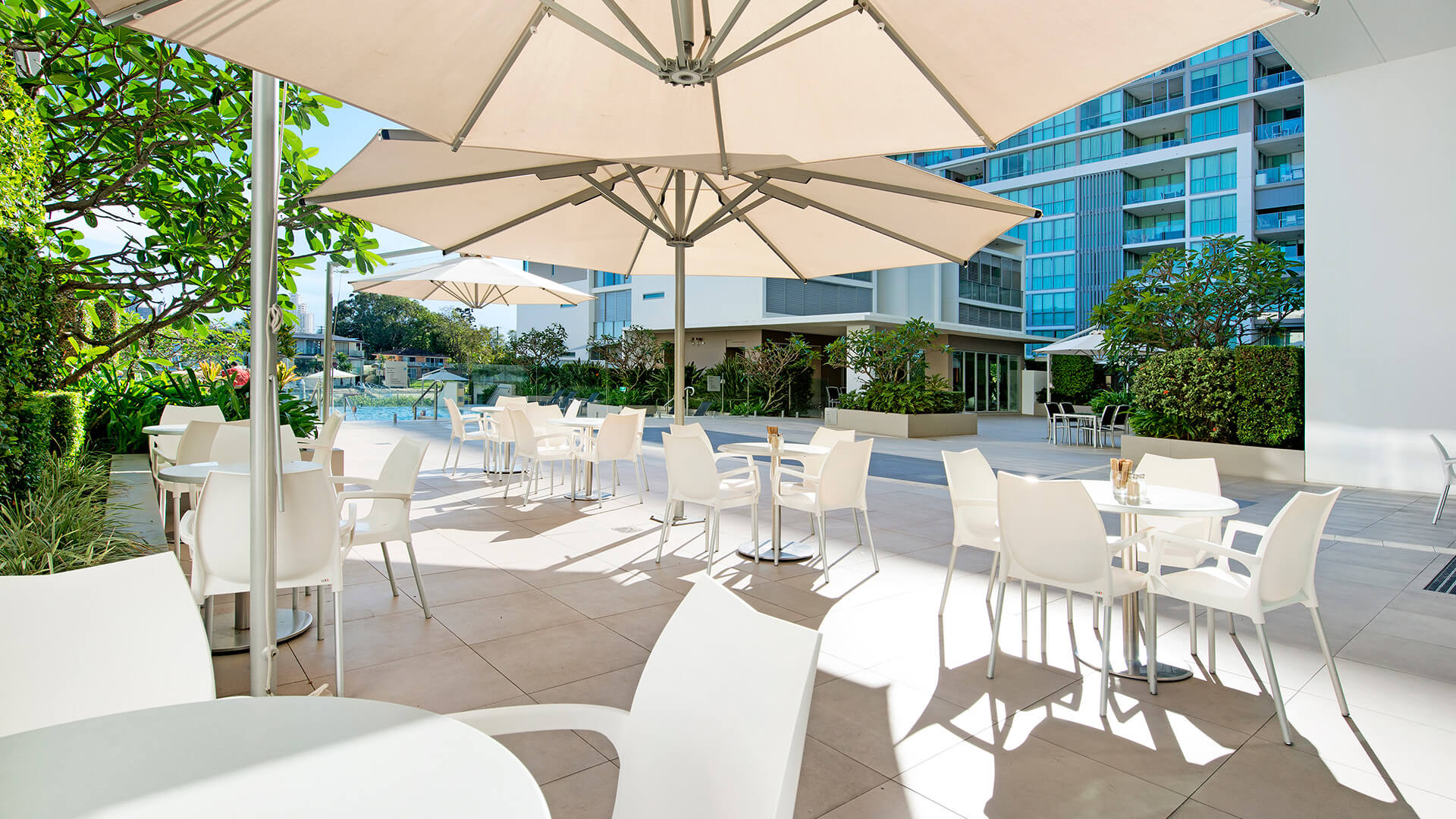 Outdoor seating with umbrellas at ULTIQA Freshwater Point Resort, Broadbeach.