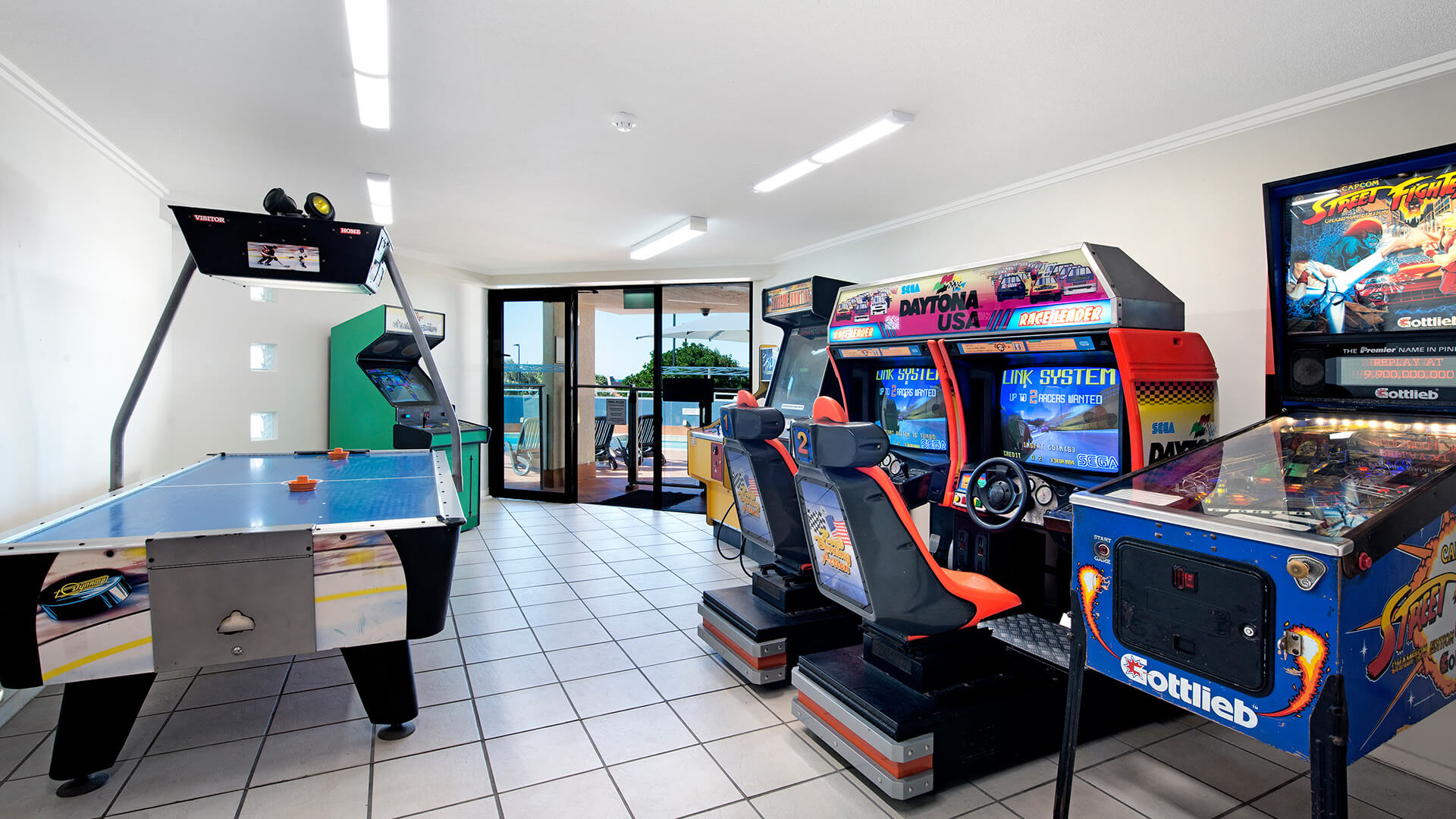 Games room with arcade machines, racing simulators, air hockey and pinball at ULTIQA Shearwater Resort.