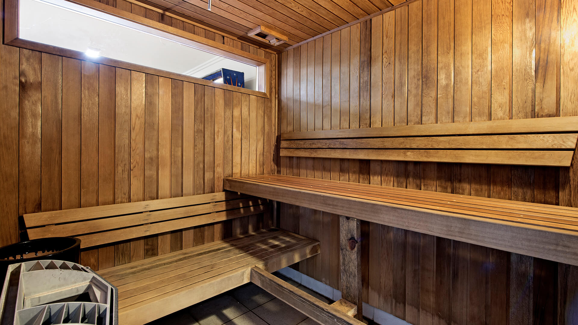 Wood-lined sauna room with bench seating at ULTIQA Shearwater Resort.