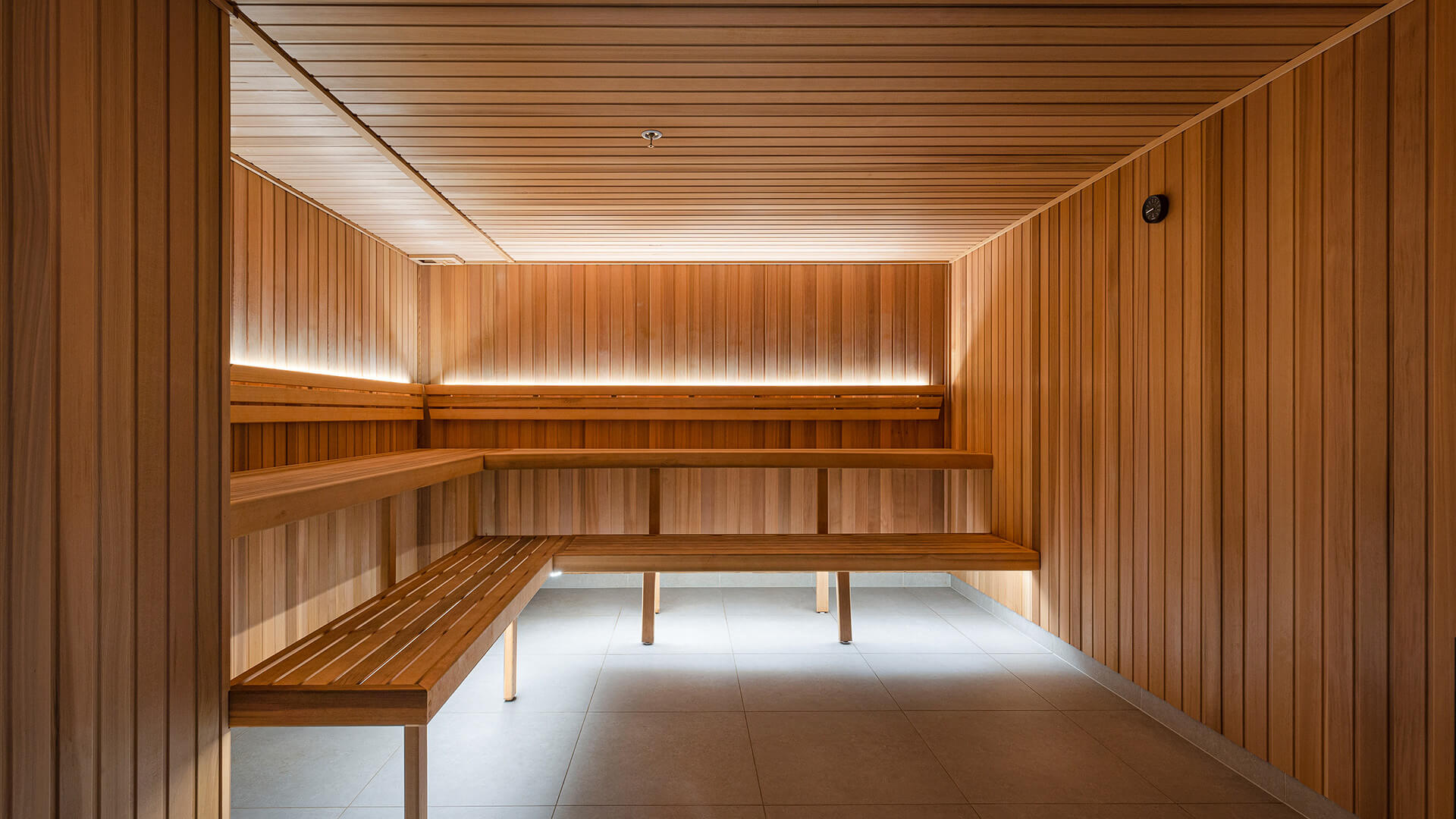 Modern wooden sauna room with tiered seating at ULTIQA Signature.