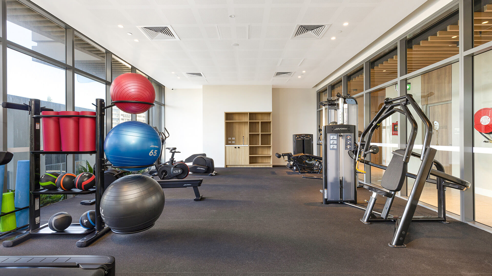 Modern gym with fitness balls, weights and exercise machines at ULTIQA Signature.