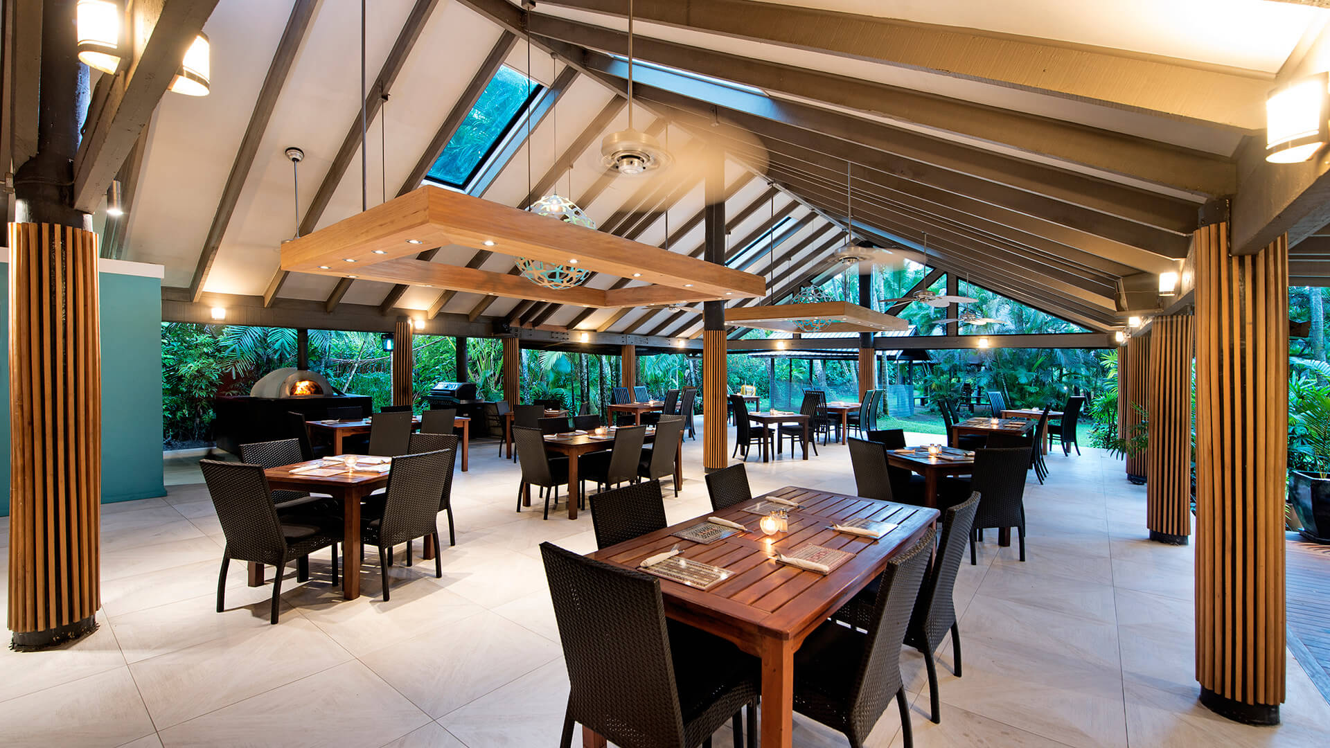 Open-air restaurant at ULTIQA Fiji with modern tropical design, wooden tables and garden views.
