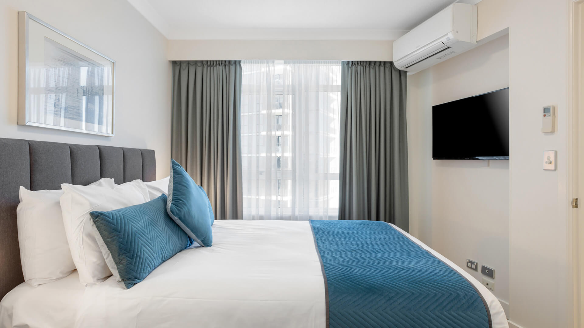 Bedroom with king bed, air conditioning, and flat-screen TV.