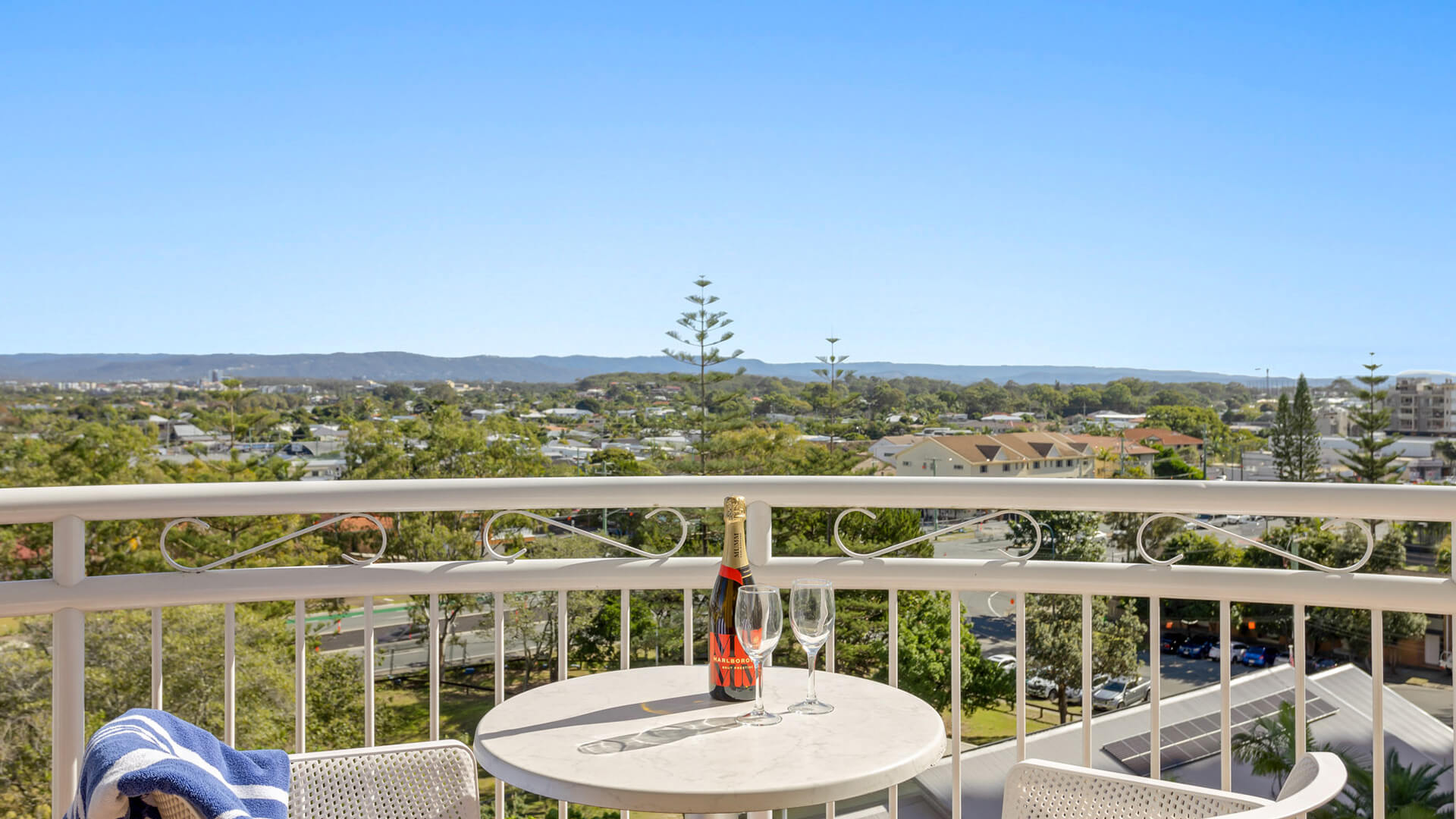 Hinterland-facing balcony featuring a table setting with wine and sweeping scenic views.