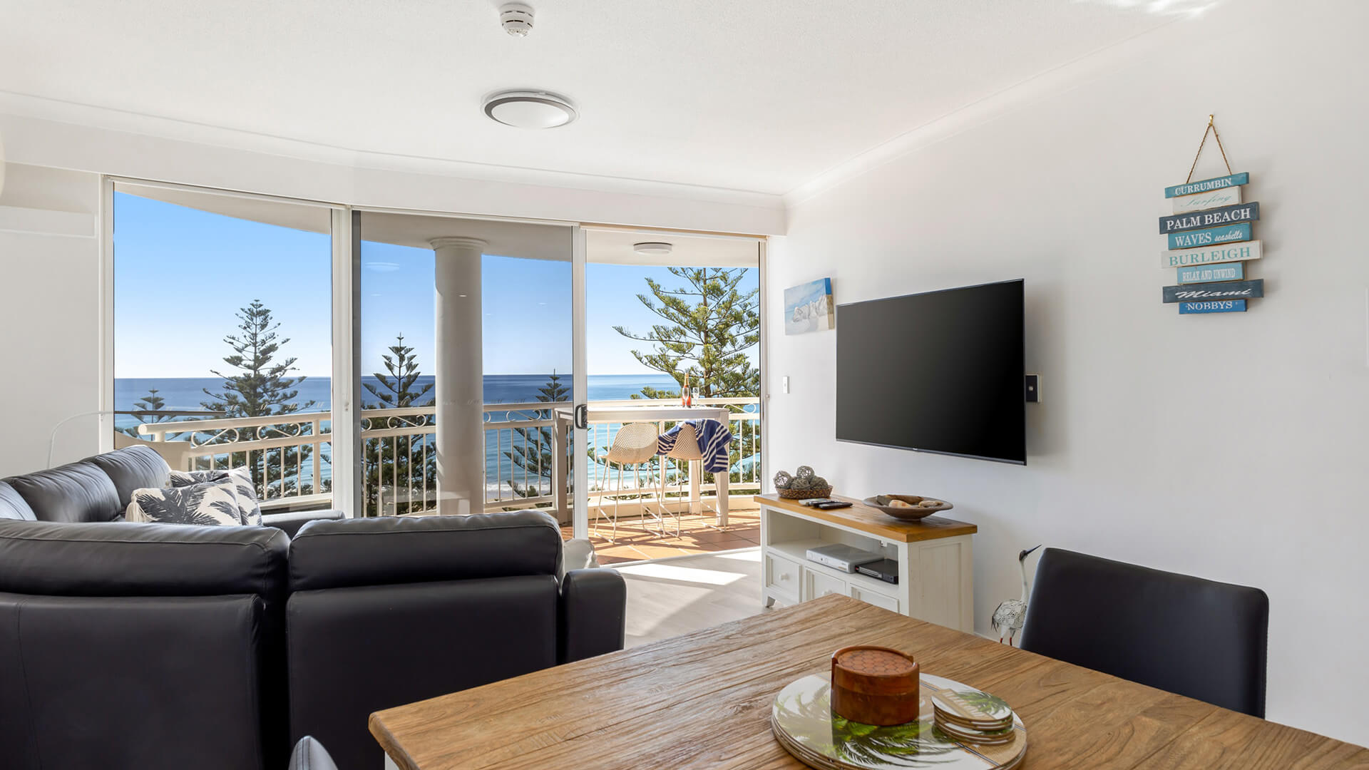 Dining and lounge area of 1 Bedroom Superior Ocean View Apartment at ULTIQA Burleigh Mediterranean Resort with balcony overlooking the ocean.