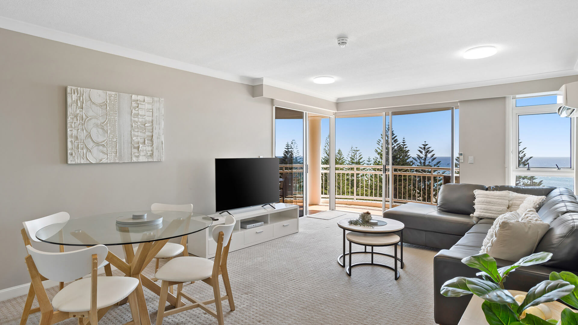 Open-plan living and dining area with ocean views in 2 Bedroom Garden View Apartment at ULTIQA Burleigh Mediterranean Resort.