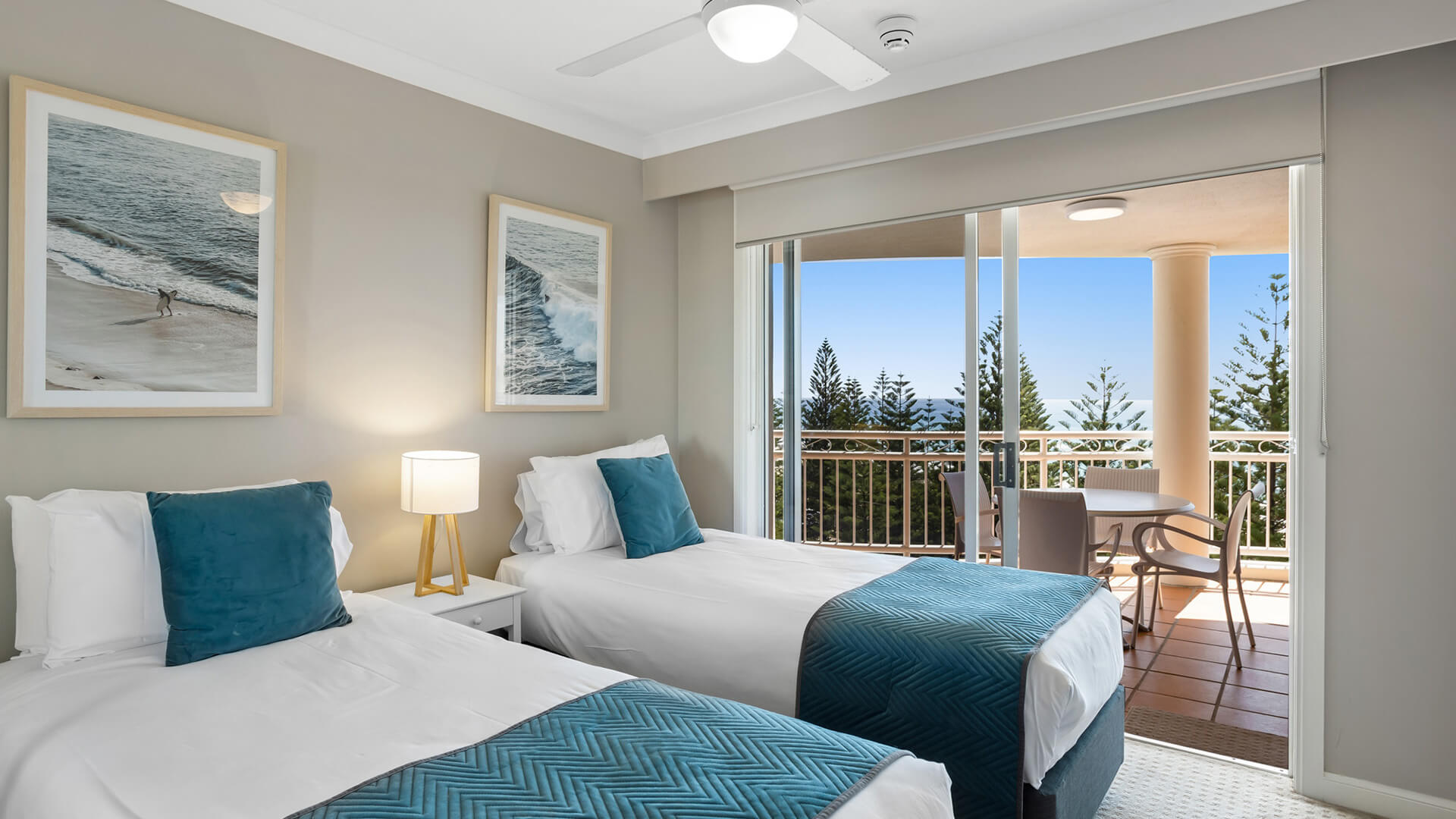 Second bedroom with twin beds and balcony access in 2 Bedroom Garden View Apartment at ULTIQA Burleigh Mediterranean Resort.