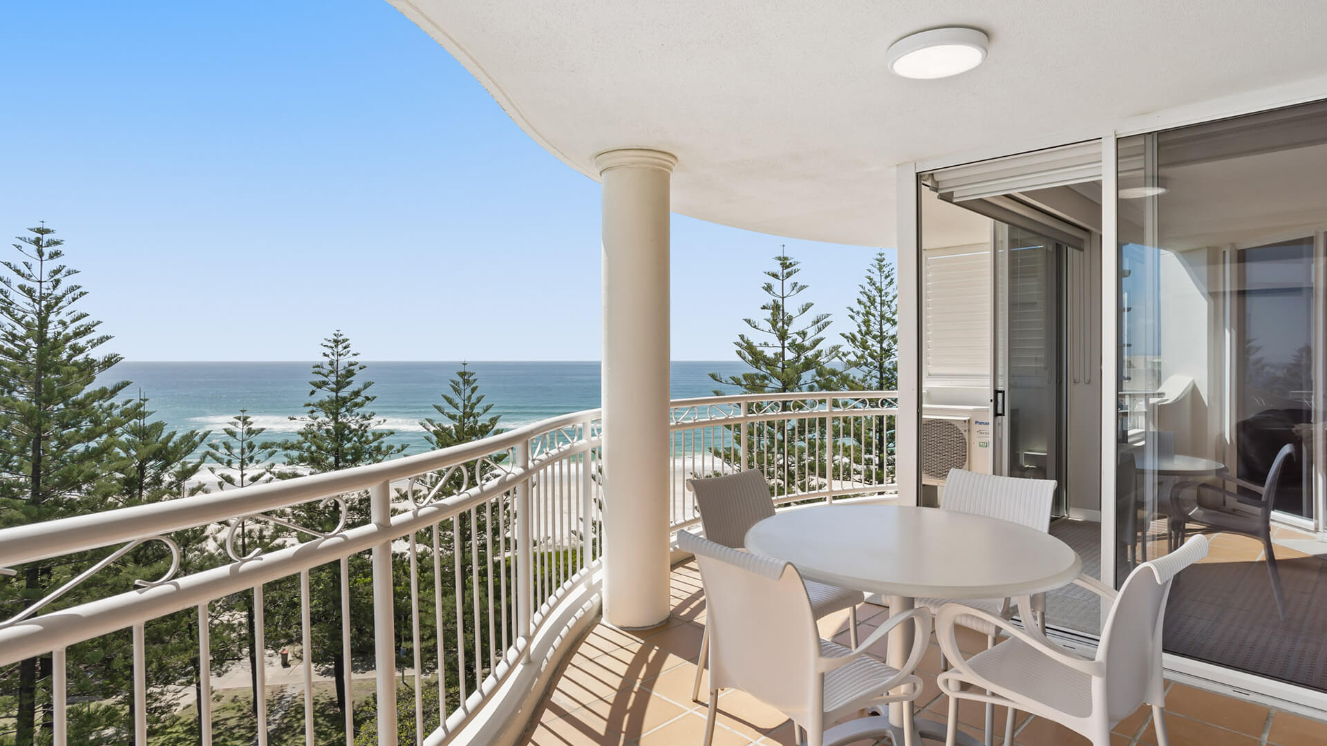 Private balcony with outdoor dining and stunning ocean views at ULTIQA Burleigh Mediterranean Resort.