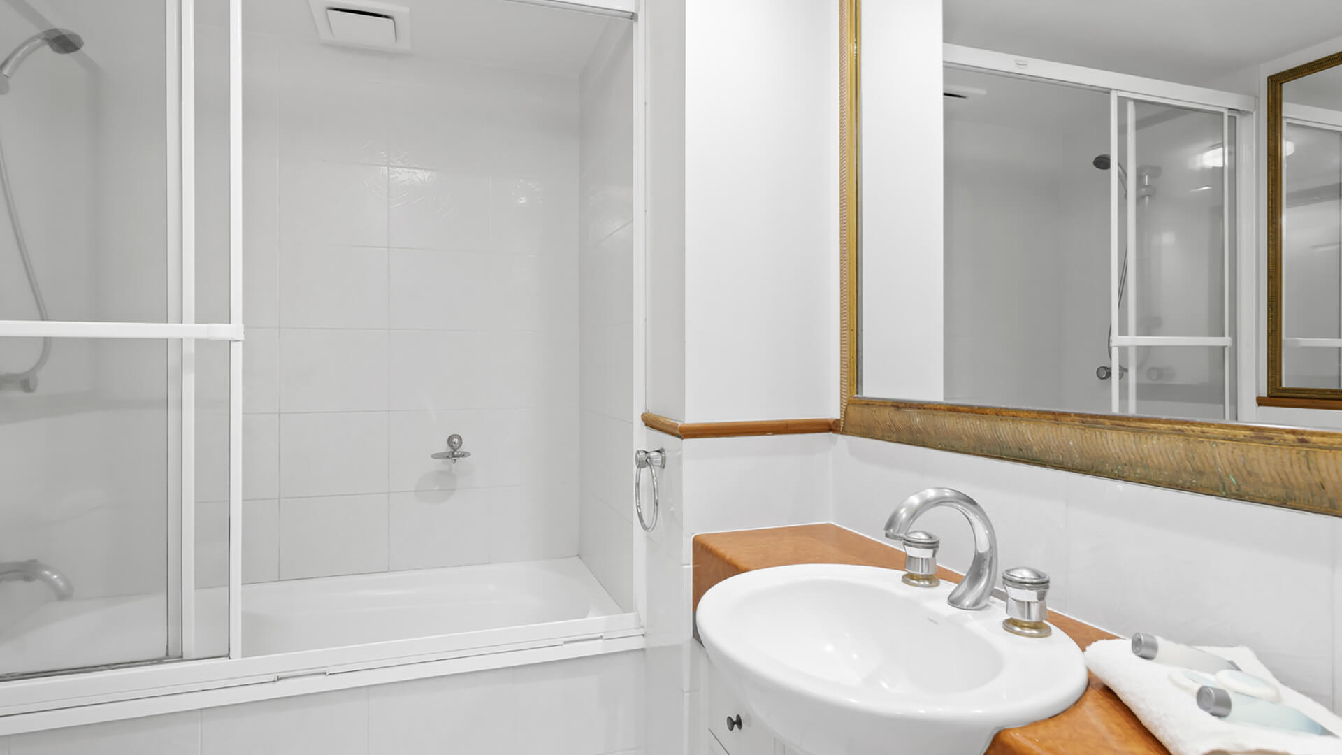 Bathroom with shower over bath in 2 Bedroom Apartment at ULTIQA Burleigh Mediterranean Resort.