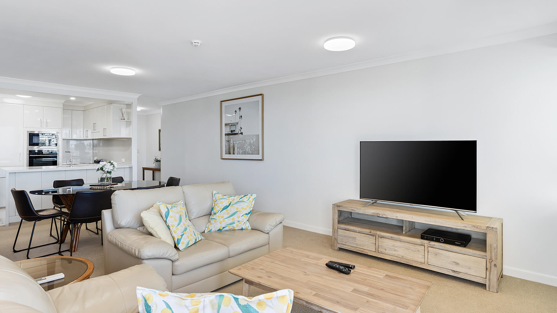 Open-plan lounge, dining, and kitchen area in 2 Bedroom Apartment at ULTIQA Burleigh Mediterranean Resort.