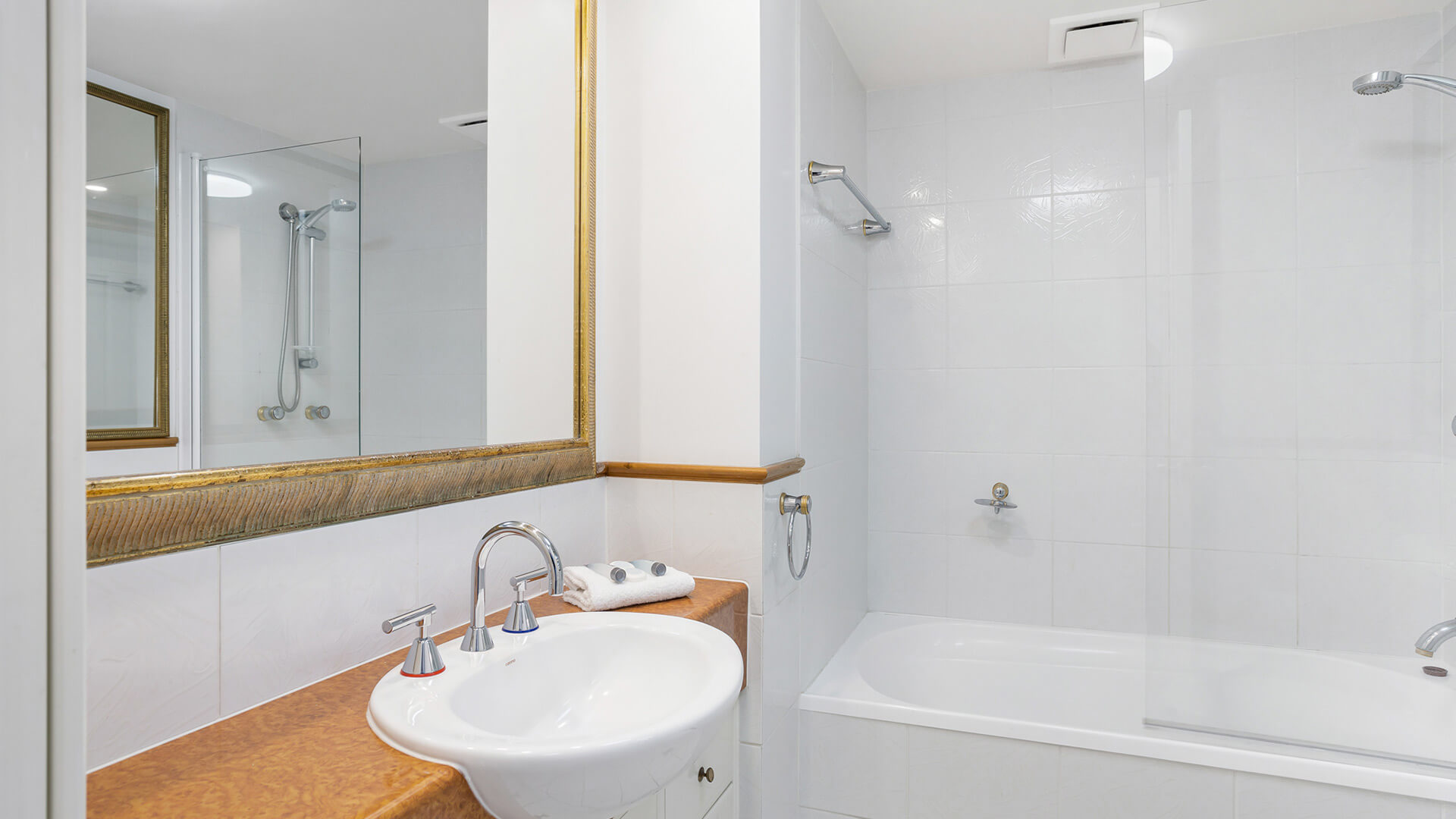Bathroom with shower over bath in 2 Bedroom Apartment at ULTIQA Burleigh Mediterranean Resort.