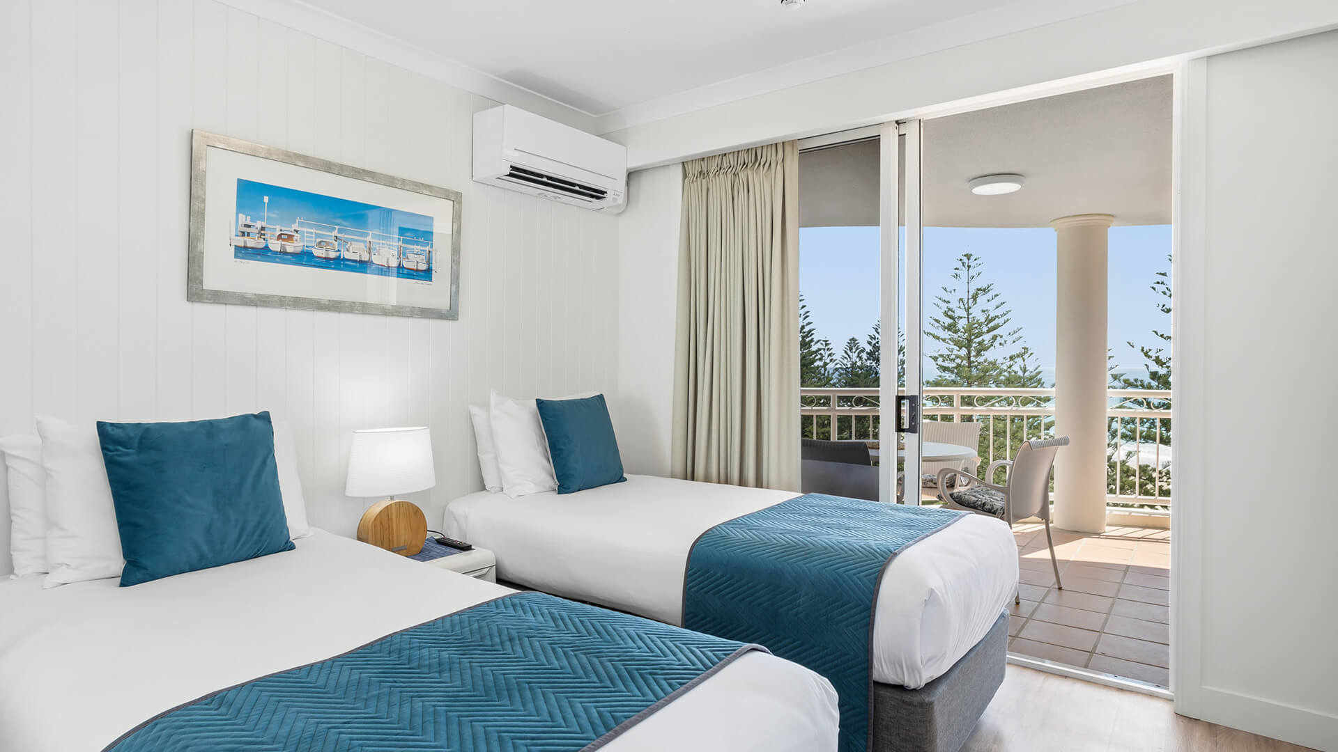Twin bedroom with ocean-view balcony in 2 Bedroom Superior Ocean View Apartment at ULTIQA Burleigh Mediterranean Resort.