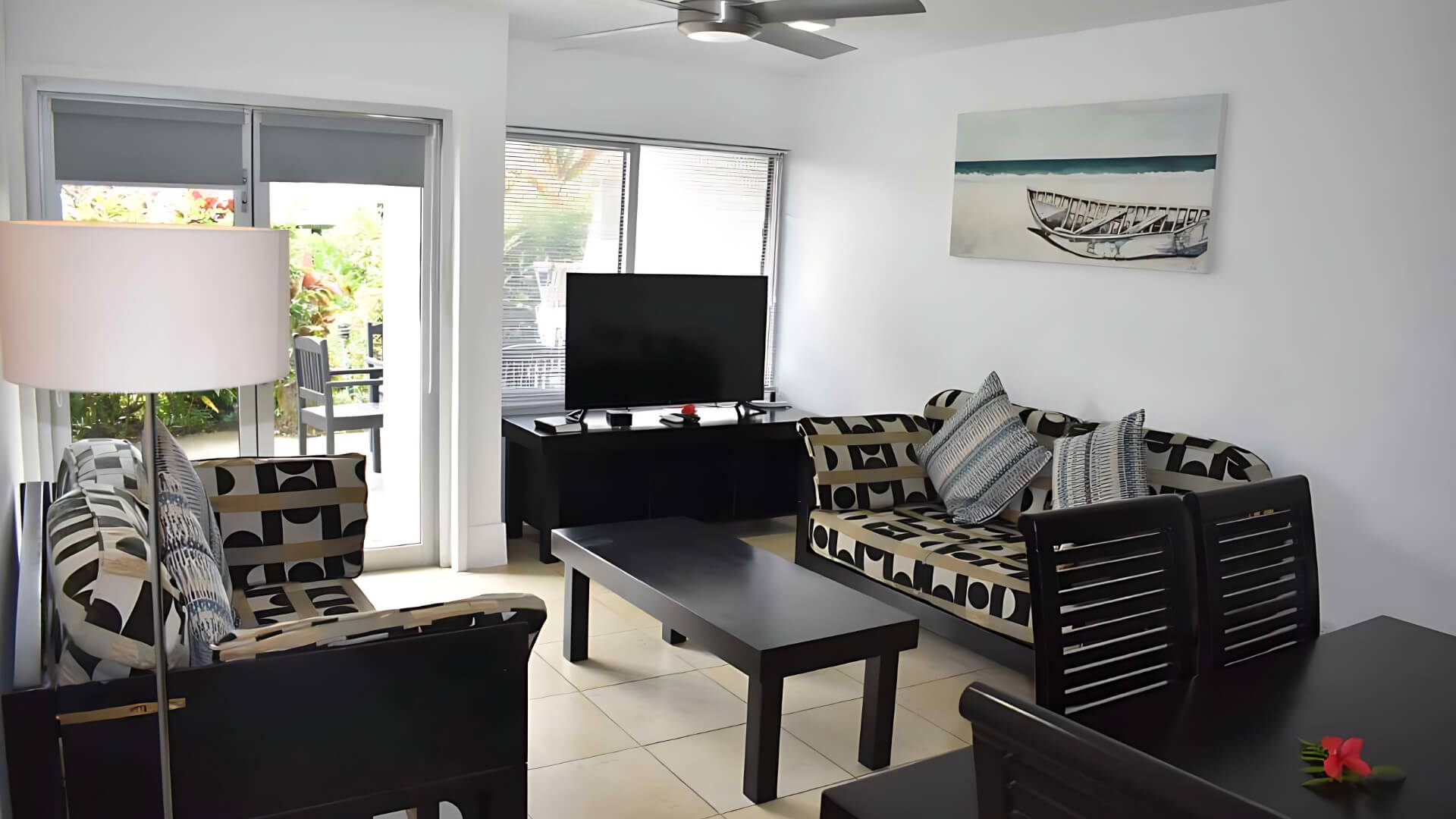 Standard 2 Bedroom 1 Bathroom Apartment living area at ULTIQA Fiji with sofas, TV, and dining table.
