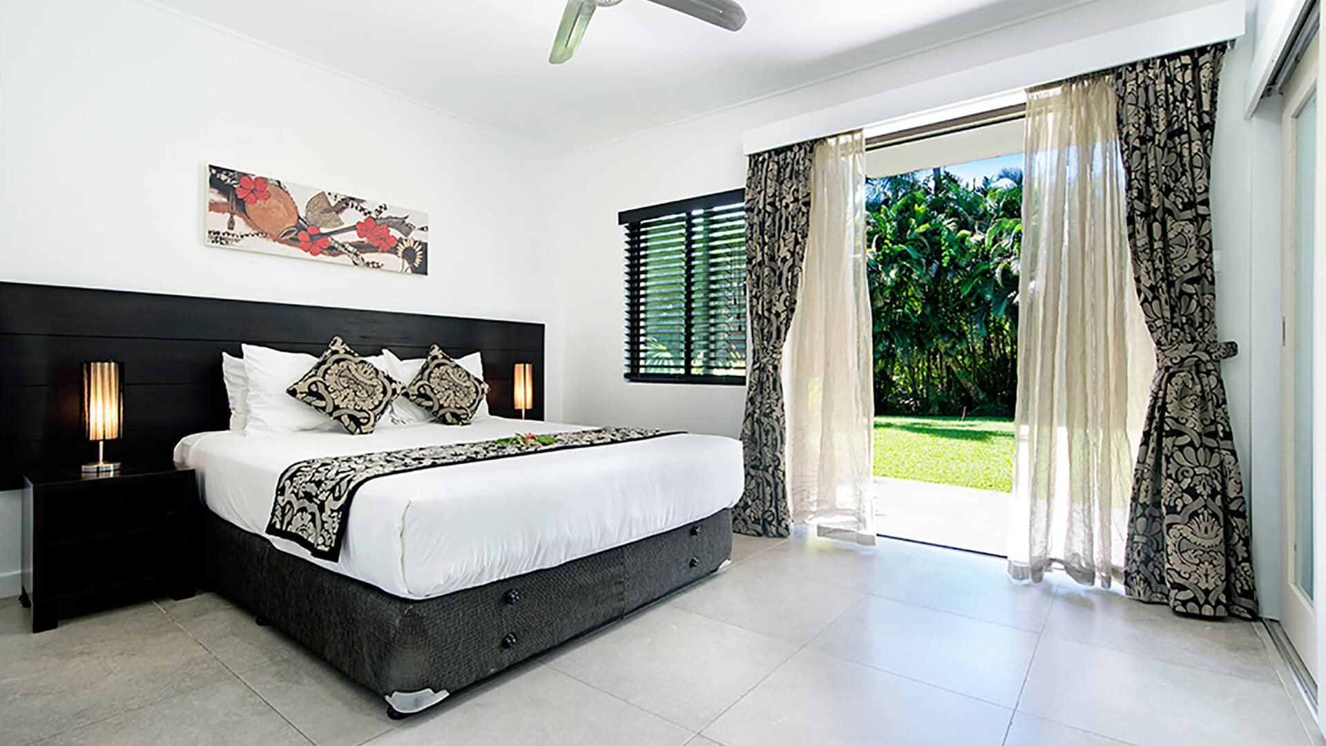 Bedroom with king bed, tropical garden views, and direct outdoor access in 2 Bedroom Apartment at ULTIQA Fiji.