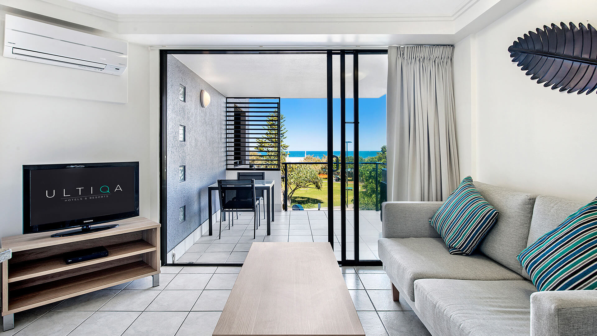 Living area of 1 Bedroom Apartment at ULTIQA Shearwater Resort with balcony and ocean views.