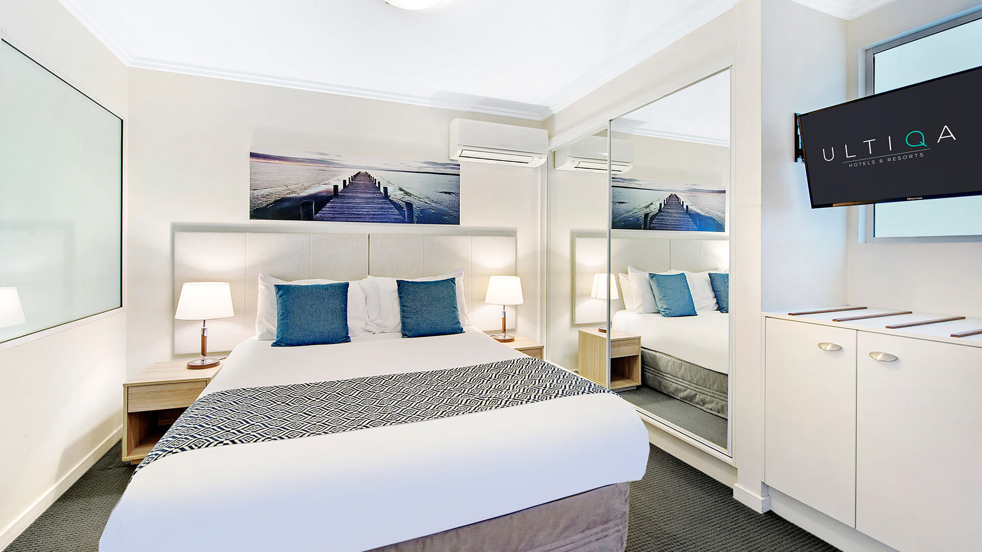 Bedroom with king bed and mirrored wardrobe in 1 Bedroom Apartment at ULTIQA Shearwater Resort.