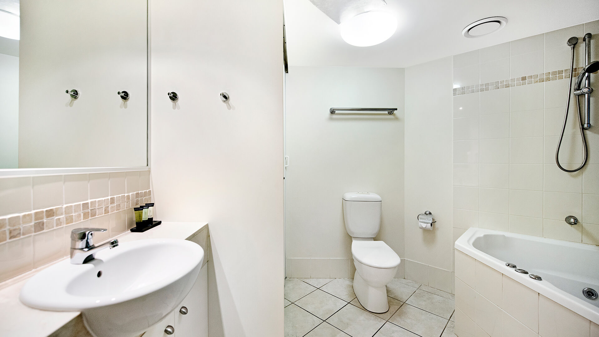 Bathroom with spa bath and shower in 1 Bedroom Apartment at ULTIQA Shearwater Resort.