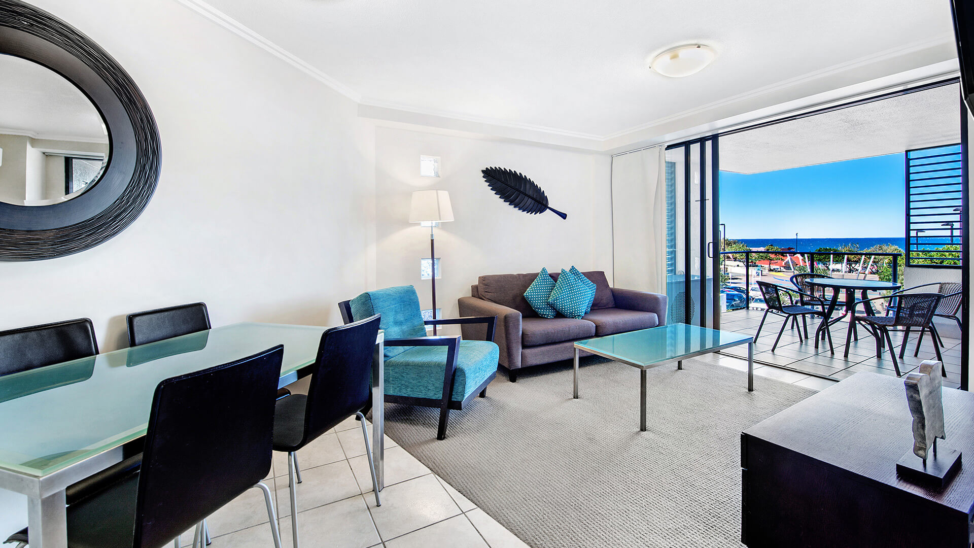 Dining and living area with balcony access in 2 Bedroom Apartment at ULTIQA Shearwater Resort.