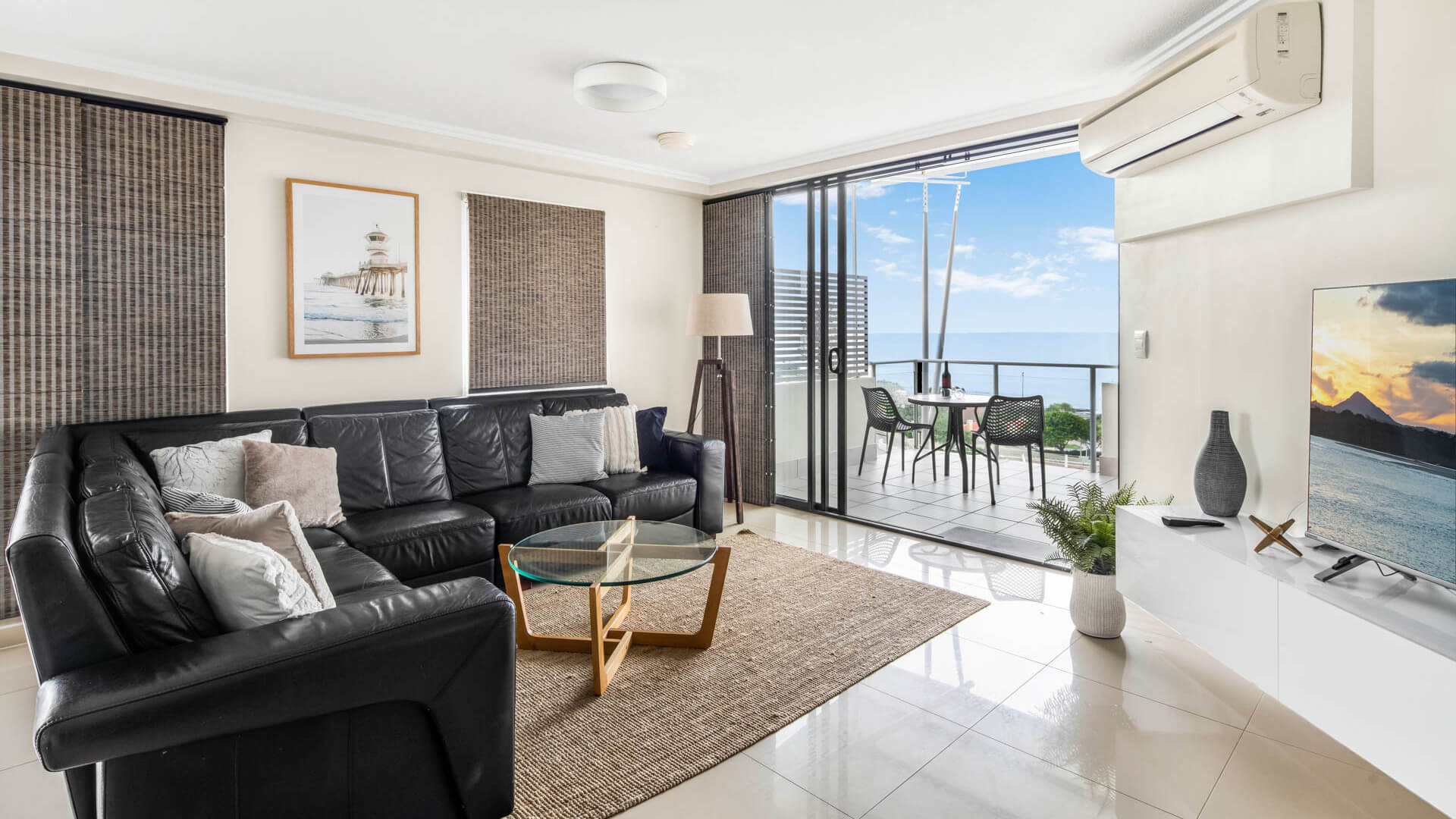 Modern living area with leather lounge and ocean-view balcony in 3 Bedroom Penthouse at ULTIQA Shearwater Resort.