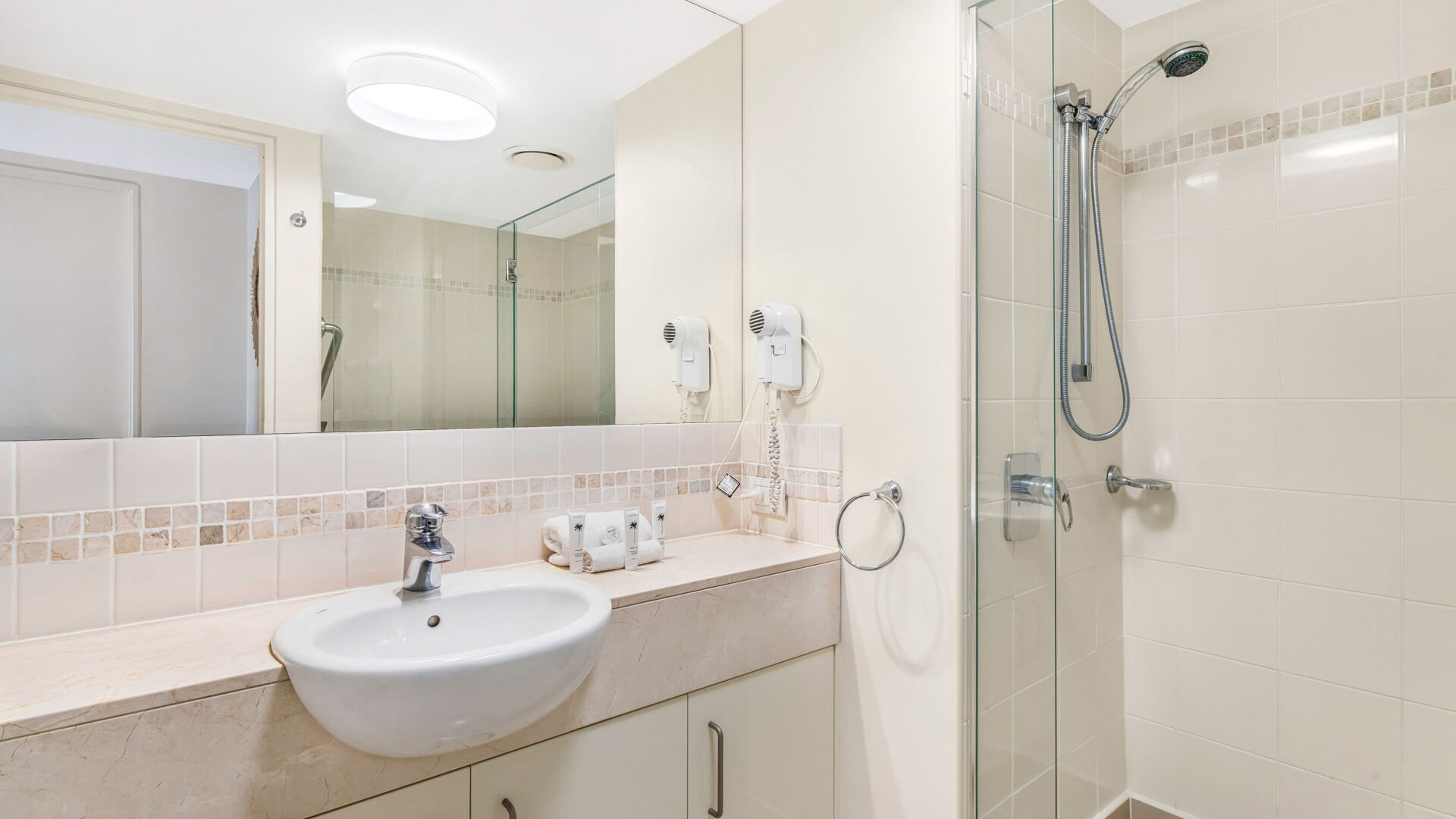 Bathroom with vanity, mirror, and walk-in shower in 3 Bedroom Penthouse at ULTIQA Shearwater Resort.