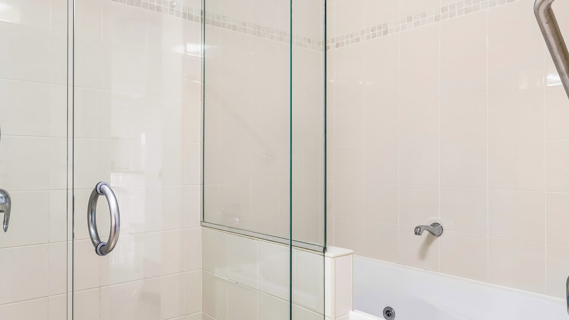 Bathroom with glass-enclosed shower and spa bath in 3 Bedroom Penthouse at ULTIQA Shearwater Resort.