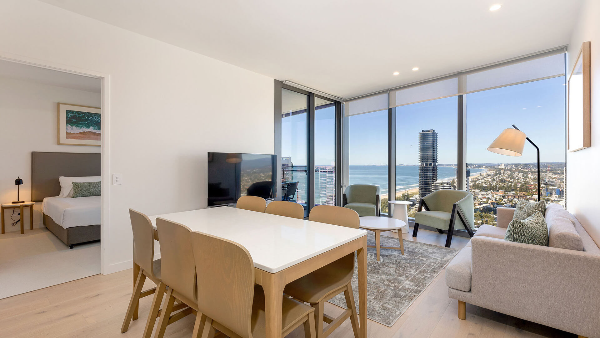 Open-plan living and dining area with ocean views in the 2 Bedroom Ocean View Suite at ULTIQA Signature at Broadbeach.