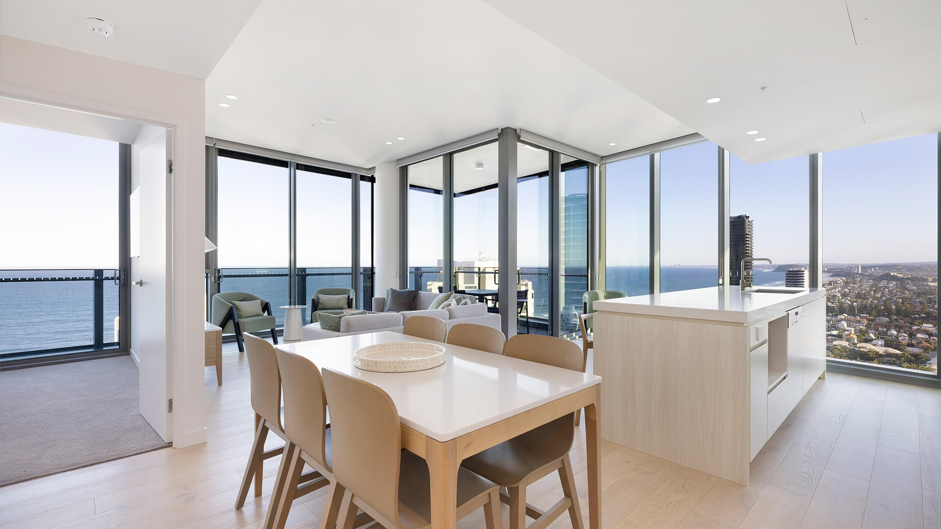 Dining and kitchen area with panoramic ocean views in the 2 Bedroom Ocean View Suite Premium at ULTIQA Signature at Broadbeach.