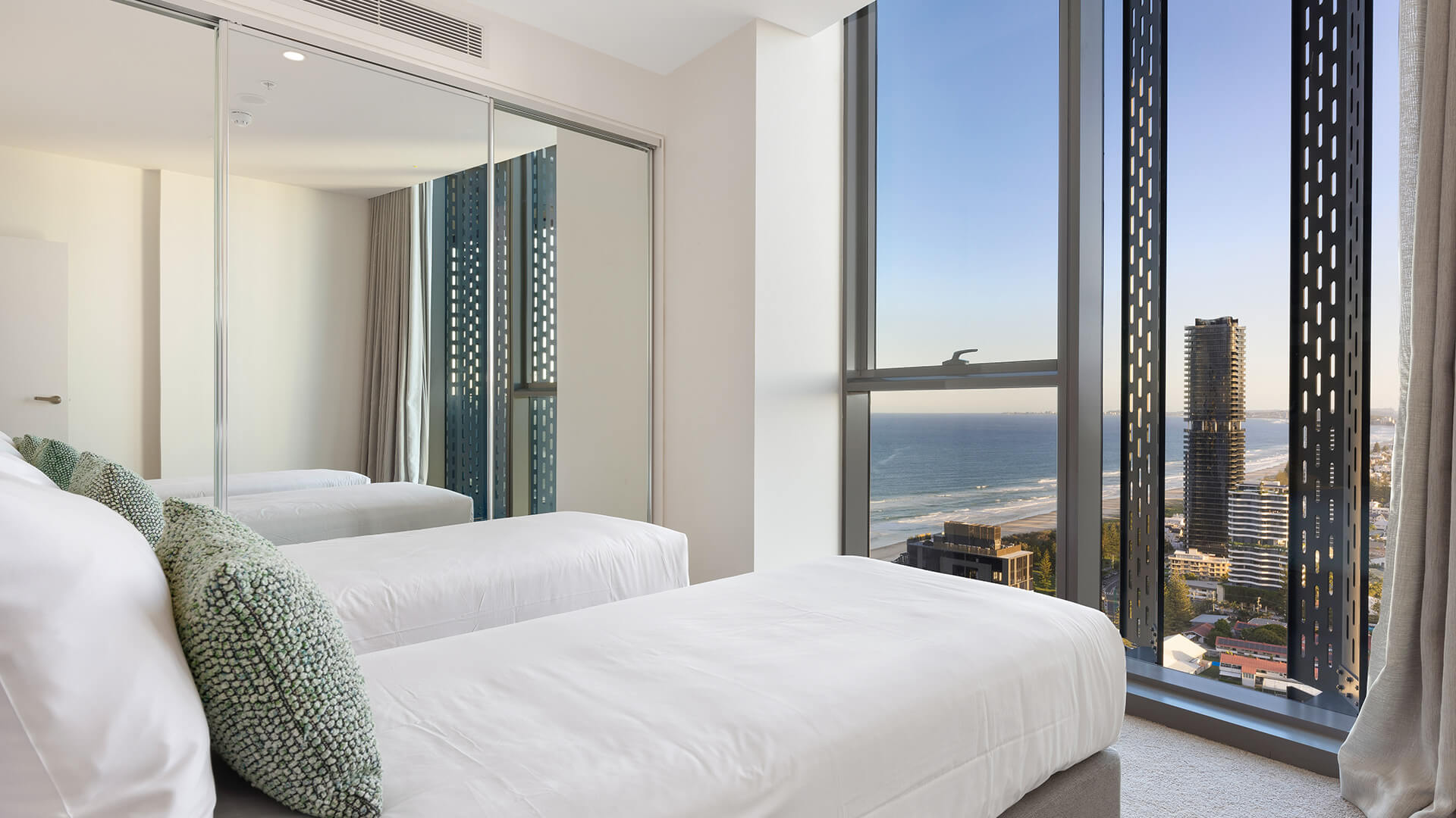 Second bedroom with twin beds and ocean views in the 2 Bedroom Ocean View Suite Premium at ULTIQA Signature at Broadbeach.