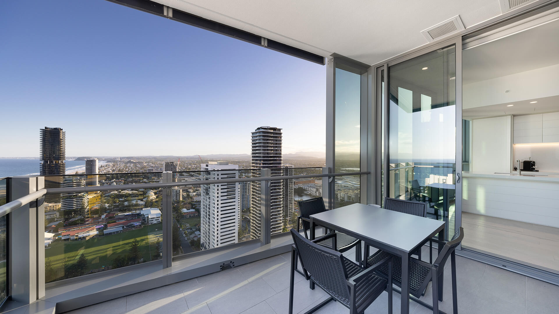 Private balcony with outdoor dining and panoramic city, ocean, and hinterland views in the 2 Bedroom Ocean View Suite Premium at ULTIQA Signature at Broadbeach.