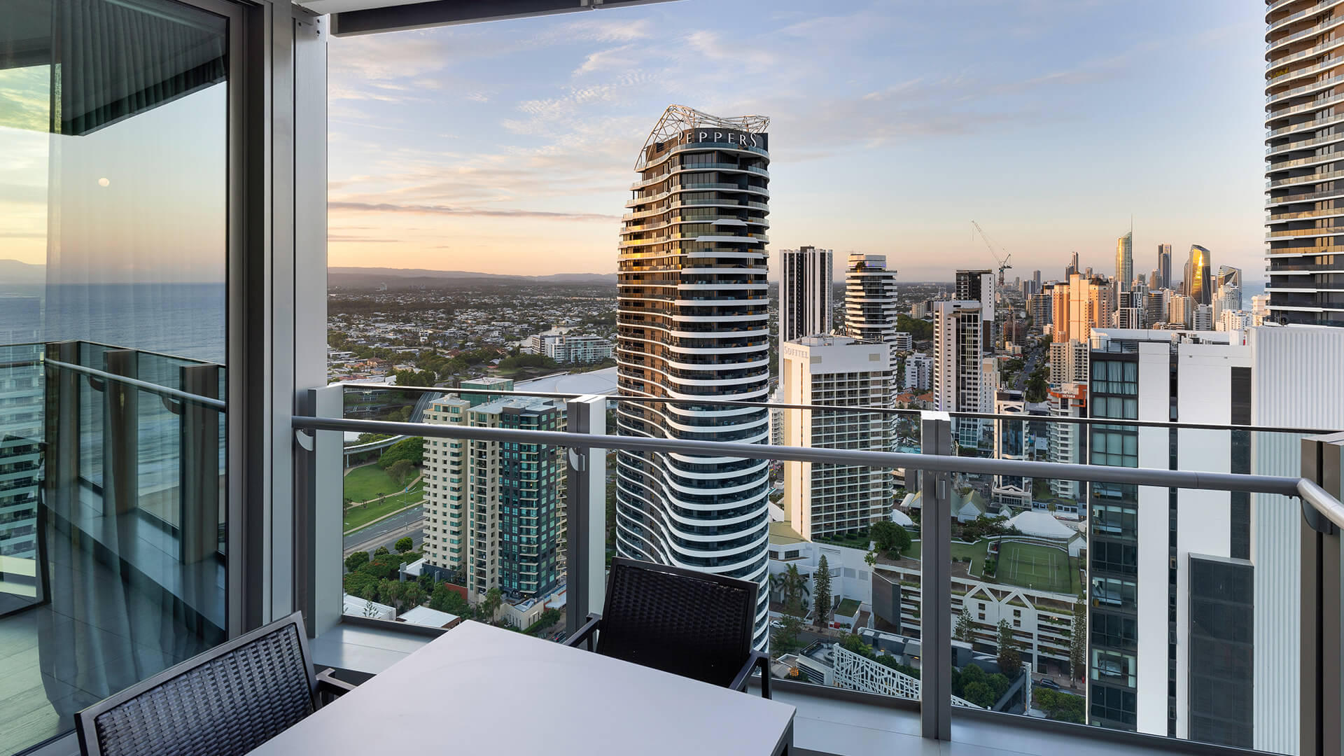 Private balcony with outdoor dining and stunning skyline, hinterland, and ocean views in the 2 Bedroom Ocean View Suite Premium at ULTIQA Signature at Broadbeach.