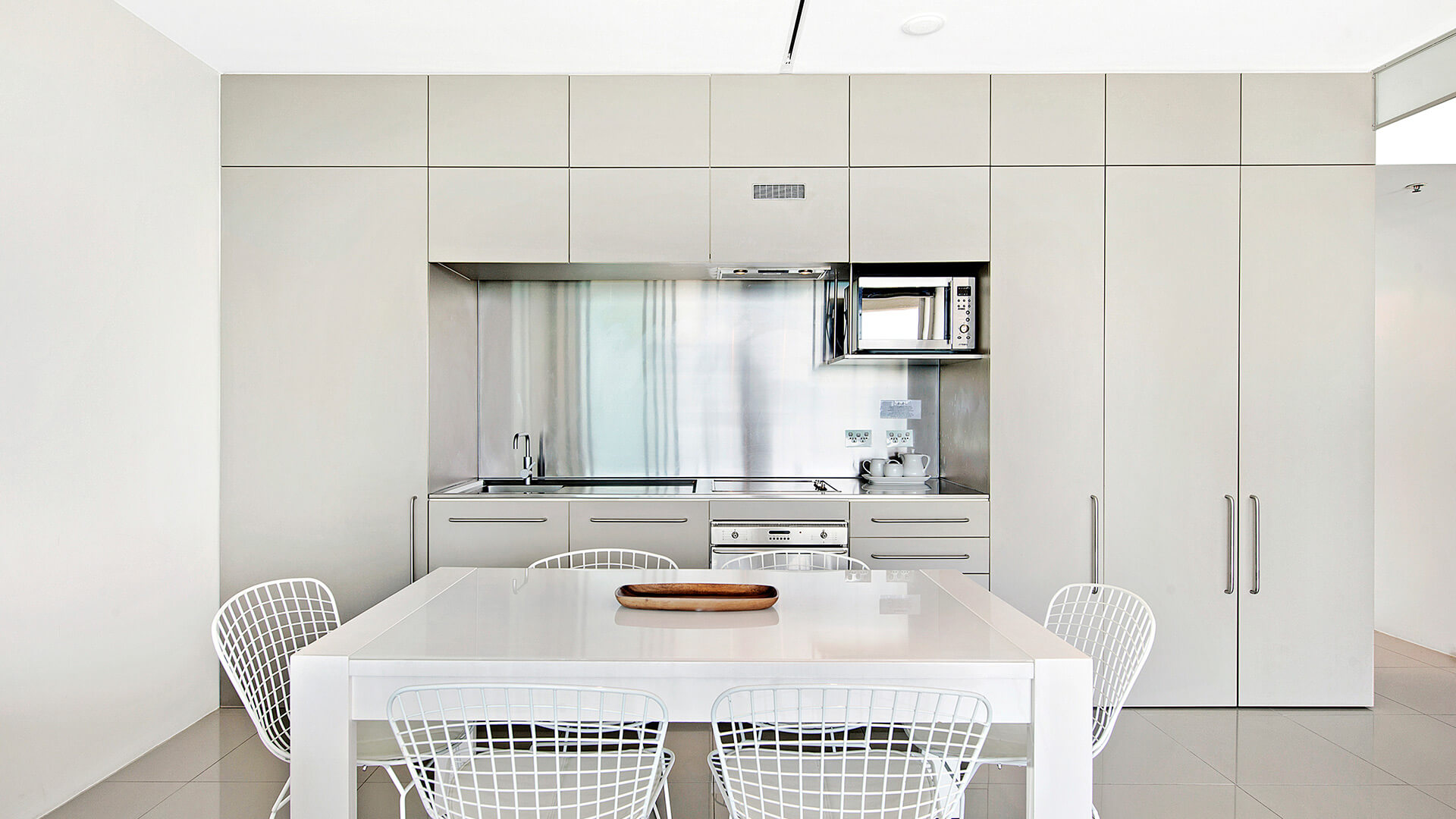 Modern kitchen and dining table in 1 Bedroom Ocean View Apartment at ULTIQA Air on Broadbeach.
