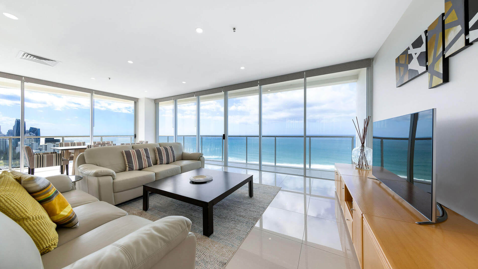 Spacious living area in ULTIQA Air’s 3 Bedroom Ocean View Suite with leather seating, ocean-facing windows, and modern décor.