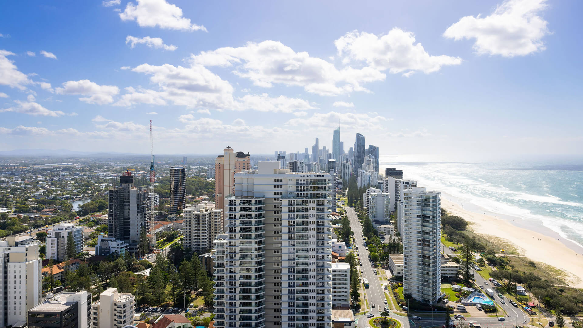 Aerial view of Gold Coast skyline with beach, ocean, and high-rise buildings along the coast.