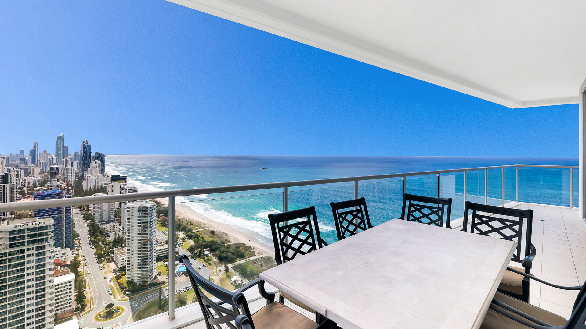 Outdoor dining on balcony with panoramic ocean and Surfers Paradise skyline views from 4 Bedroom Ocean View Apartment at ULTIQA Air on Broadbeach.