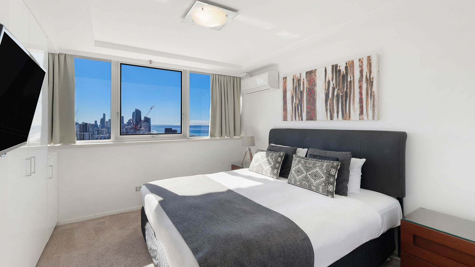 Light-filled bedroom in the Sub Penthouse at ULTIQA Beach Haven, featuring city and ocean views.