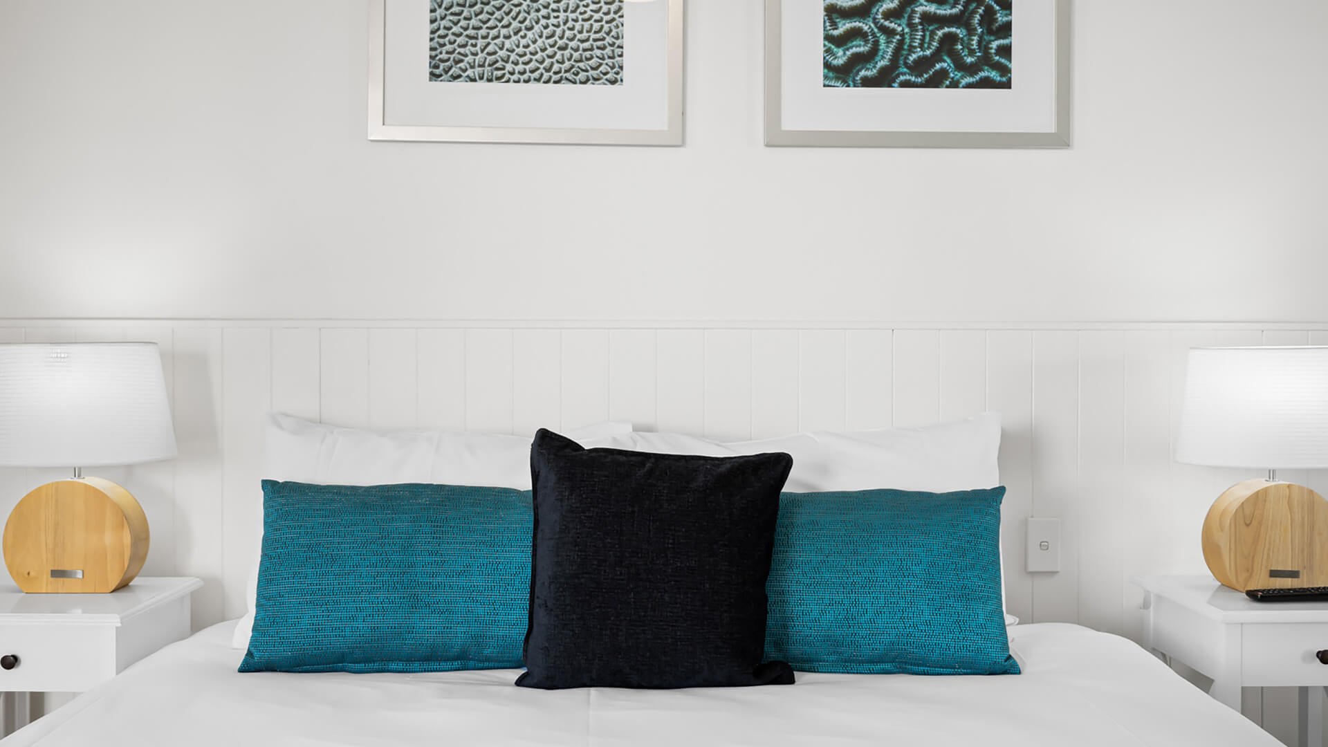 King bed in the 1 Bedroom Apartment at ULTIQA Burleigh Mediterranean Resort with decorative cushions and bedside lamps.