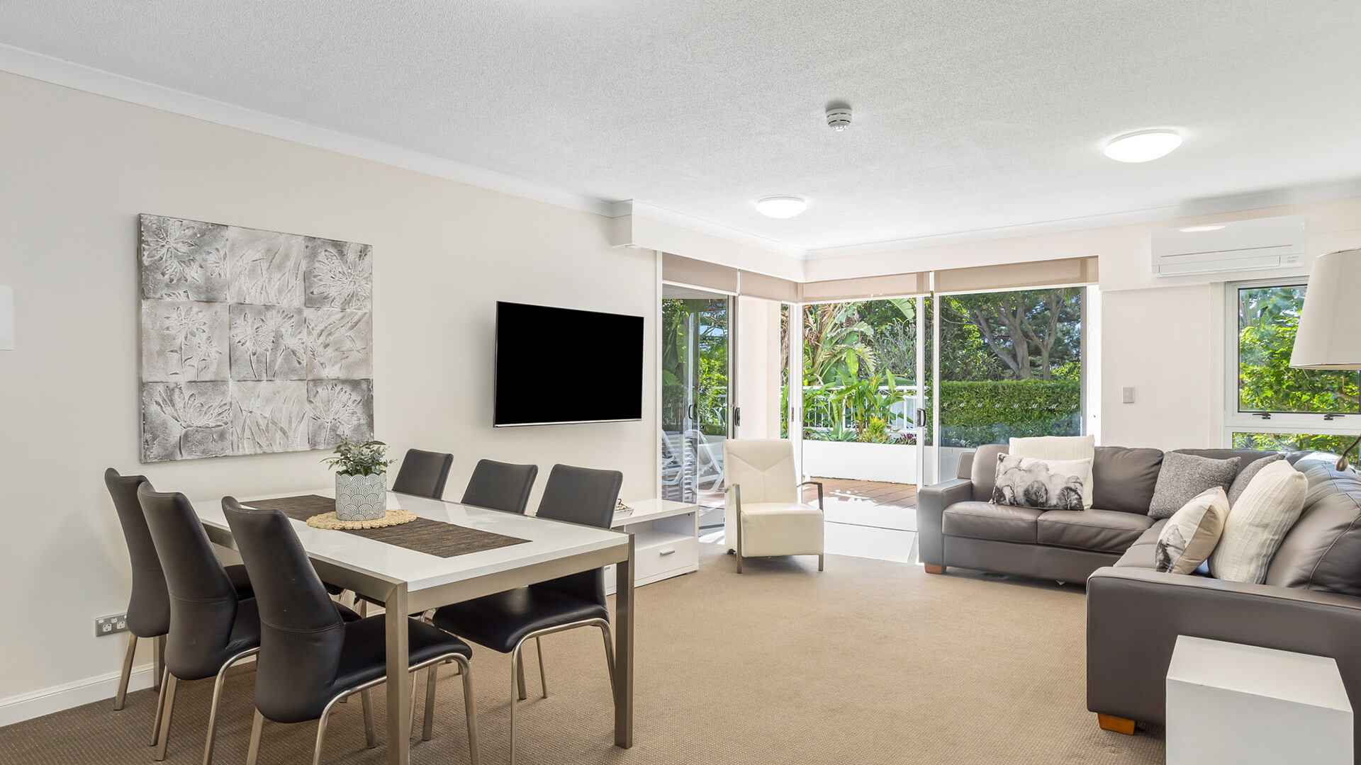 Spacious lounge and dining area in 2 Bedroom Garden View Apartment at ULTIQA Burleigh Mediterranean Resort.