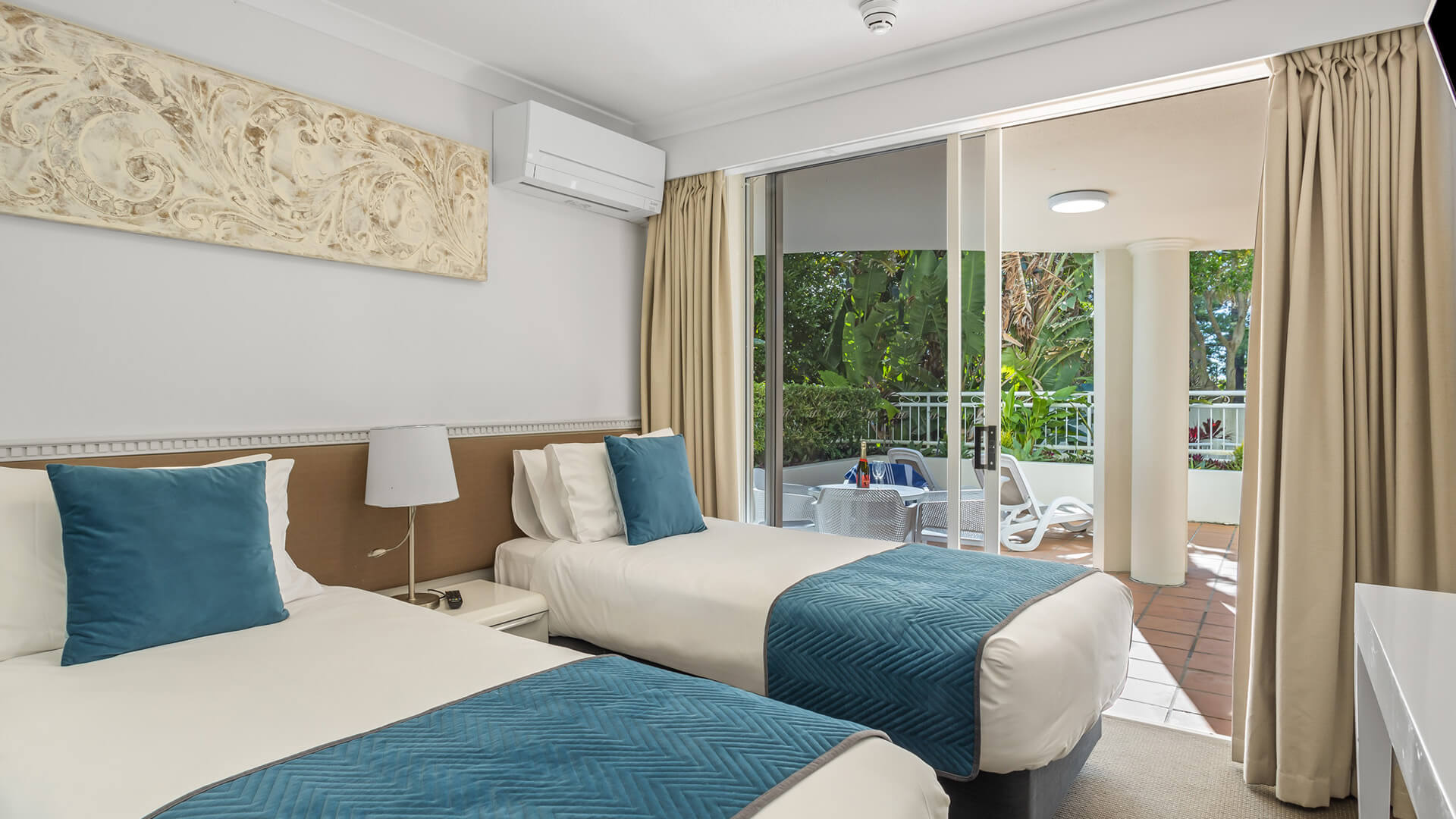 Twin bedroom with garden-view balcony in 2 Bedroom Garden View Apartment at ULTIQA Burleigh Mediterranean Resort.