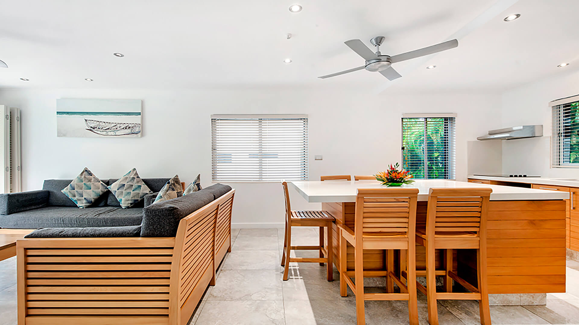 Open-plan kitchen and lounge in 2 Bedroom Deluxe Apartment at ULTIQA Fiji with modern furnishings and island bench seating.