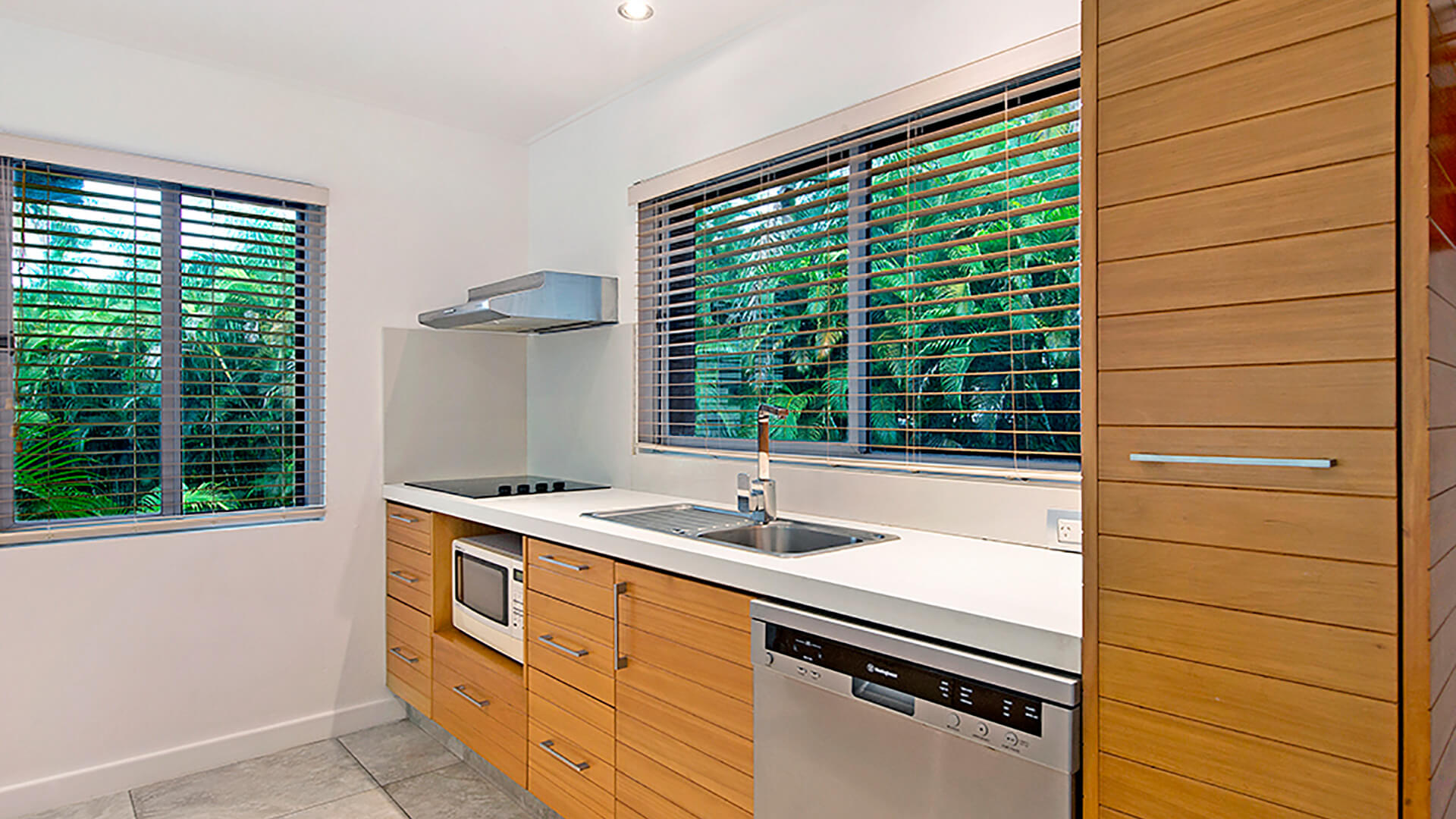 Fully equipped kitchen in 2 Bedroom Deluxe Apartment at ULTIQA Fiji with modern appliances and garden views.