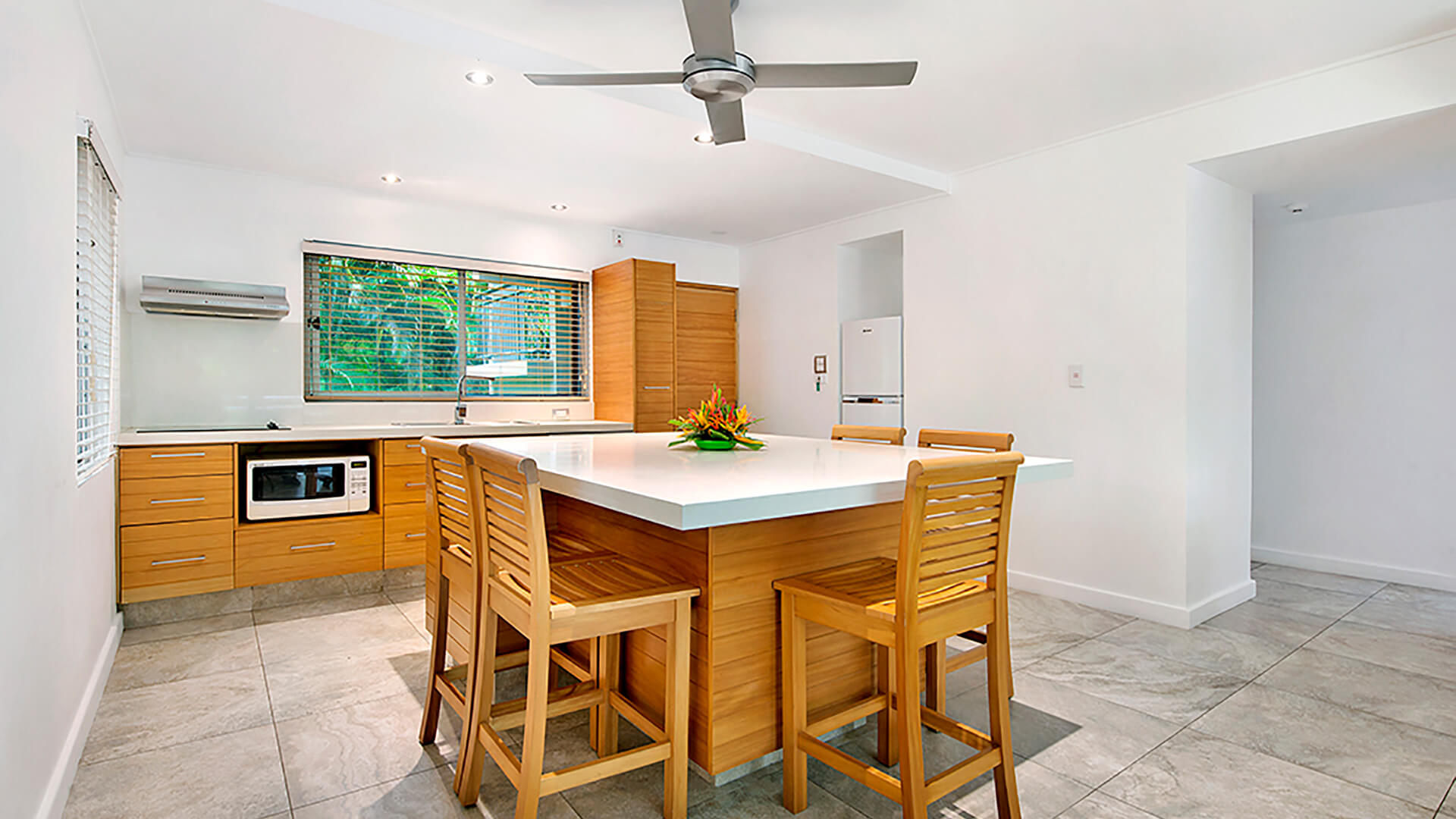 Spacious kitchen and dining area in 2 Bedroom Deluxe Apartment at ULTIQA Fiji with island bench seating and modern appliances.
