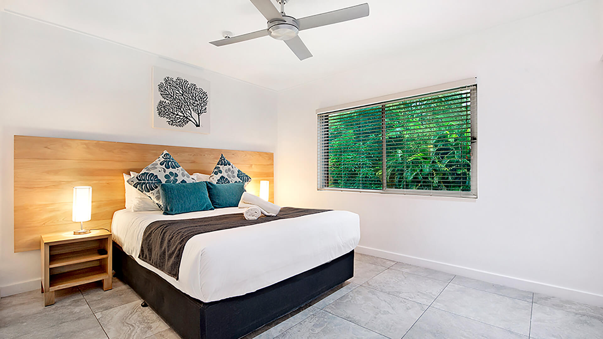Bright master bedroom in 2 Bedroom Deluxe Apartment at ULTIQA Fiji with king bed, modern decor, and tropical garden views.