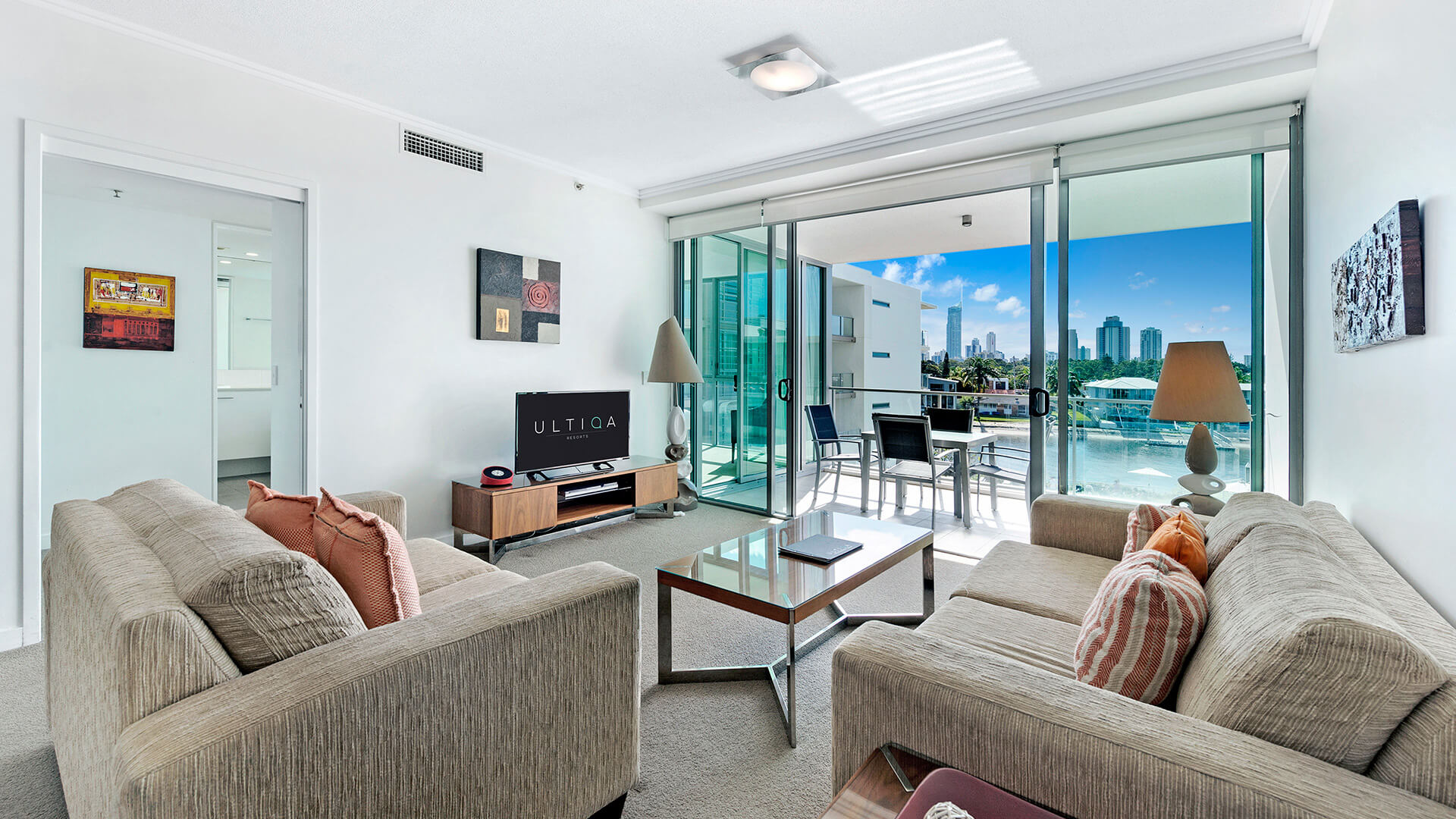 Open-plan living area in the 1 Bedroom Apartment at ULTIQA Freshwater Point Resort, with balcony access and waterway views.