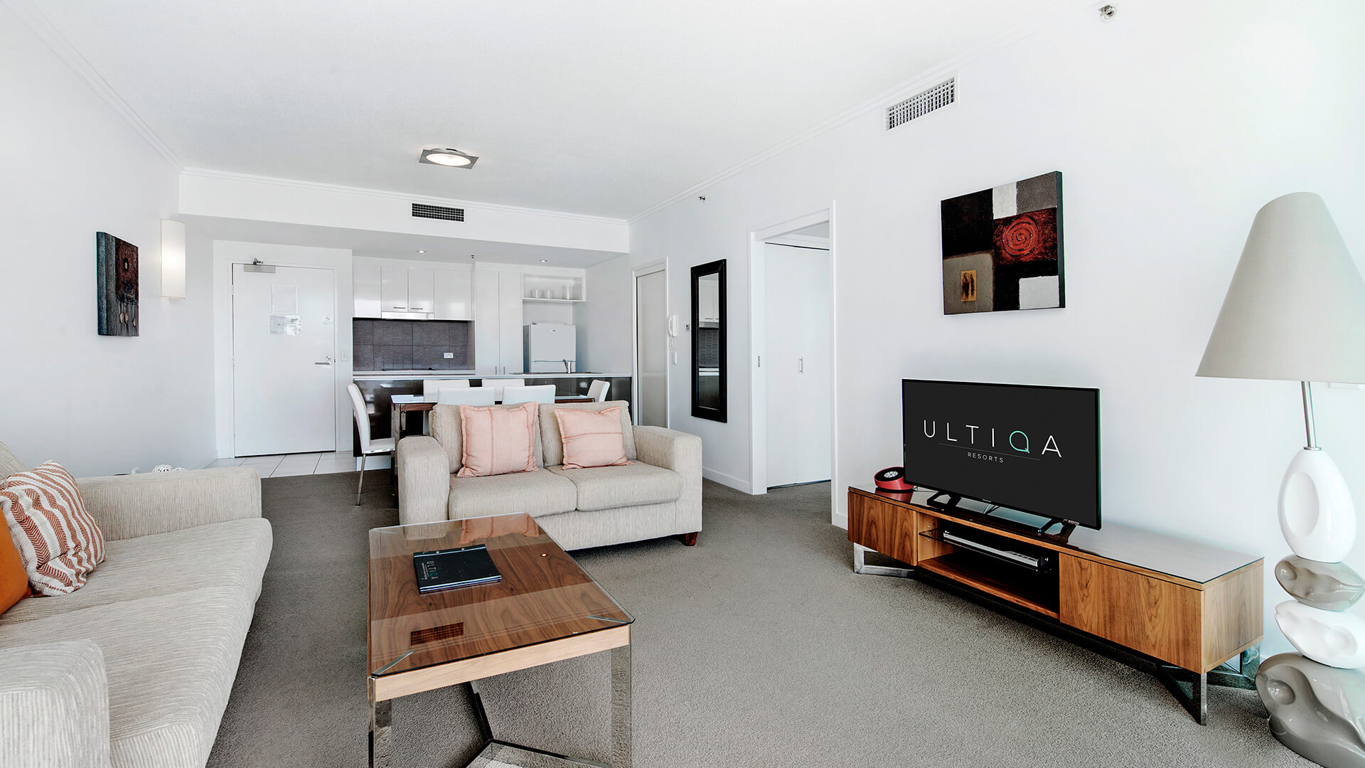 Spacious lounge and dining area in the 1 Bedroom Apartment at ULTIQA Freshwater Point Resort, complete with smart TV and kitchen.