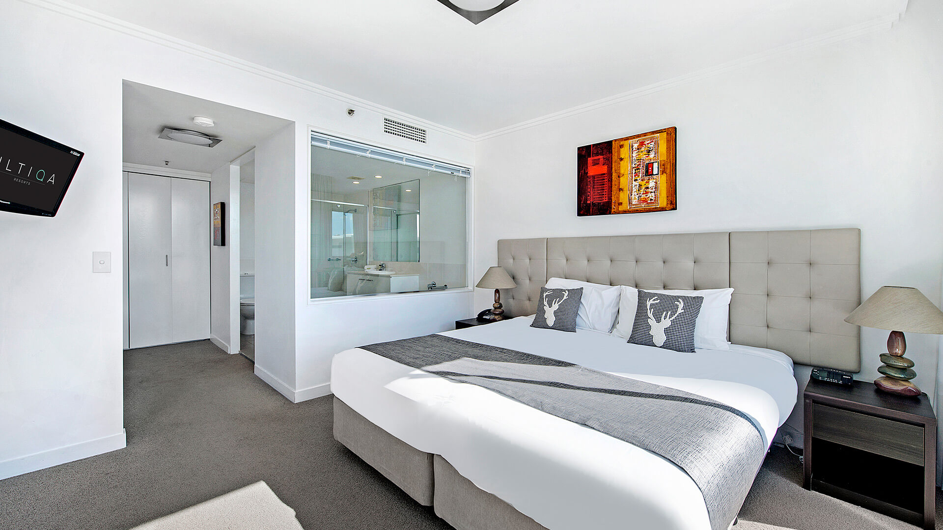 Bedroom in the 1 Bedroom Apartment at ULTIQA Freshwater Point Resort featuring a plush king bed and open ensuite with spa bath.