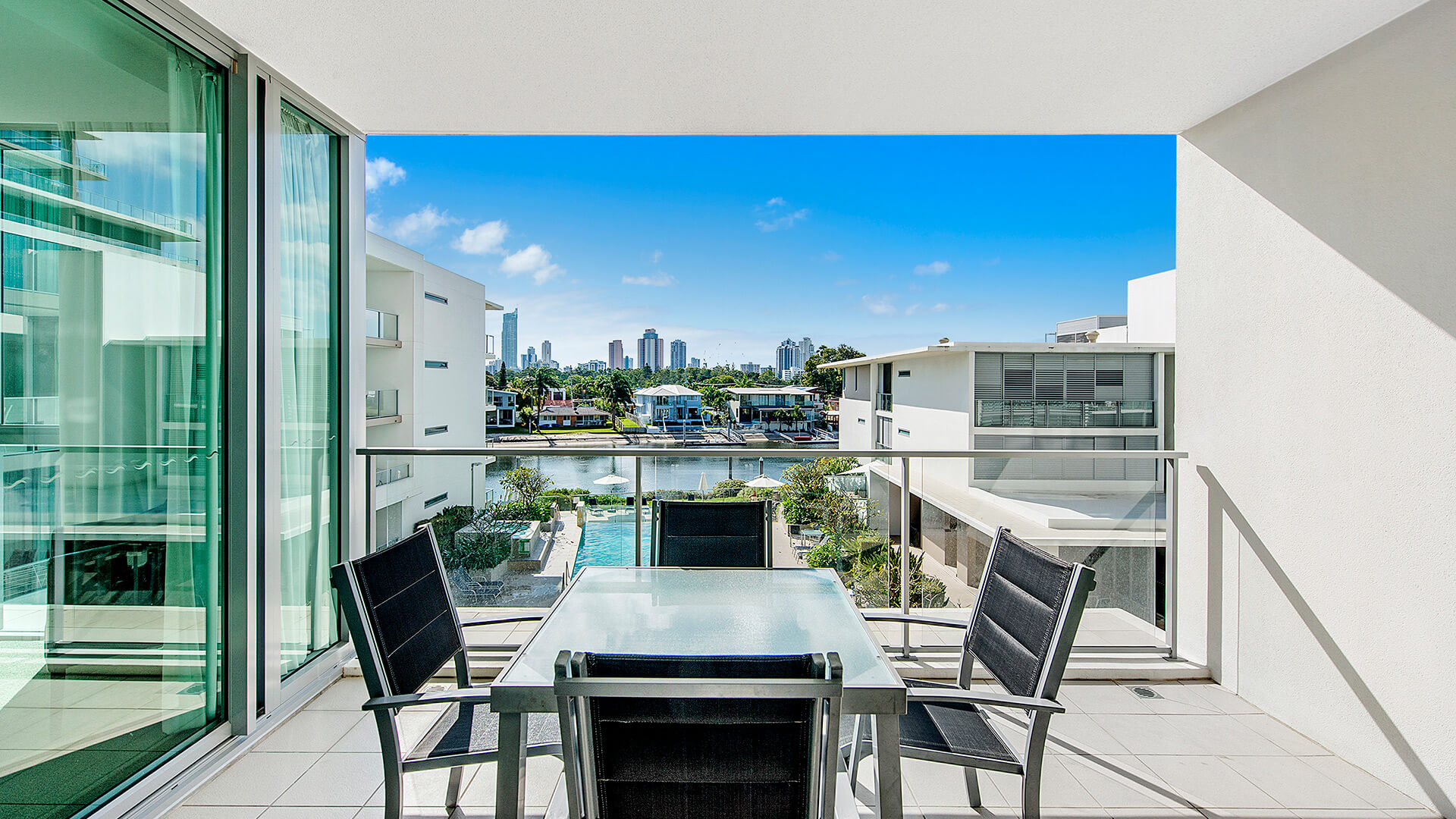 Private balcony in the 1 Bedroom Apartment at ULTIQA Freshwater Point Resort with outdoor dining and canal views.